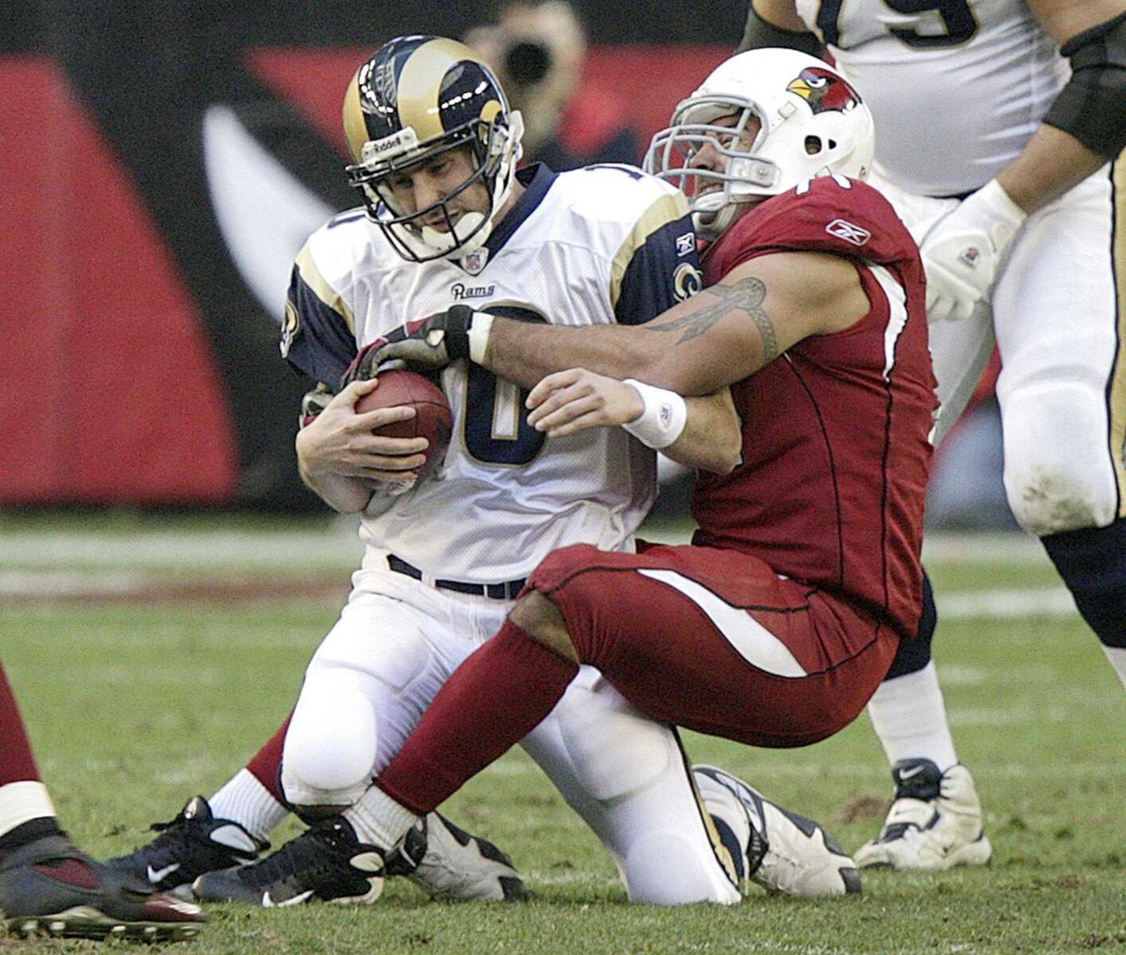 Rams quarterback Marc Bulger was sacked by Cardinals defensive end Joe Tafoya during the second quarter Sunday in Glendale, Ariz. (PAUL CONNORS ~ Associated Press)