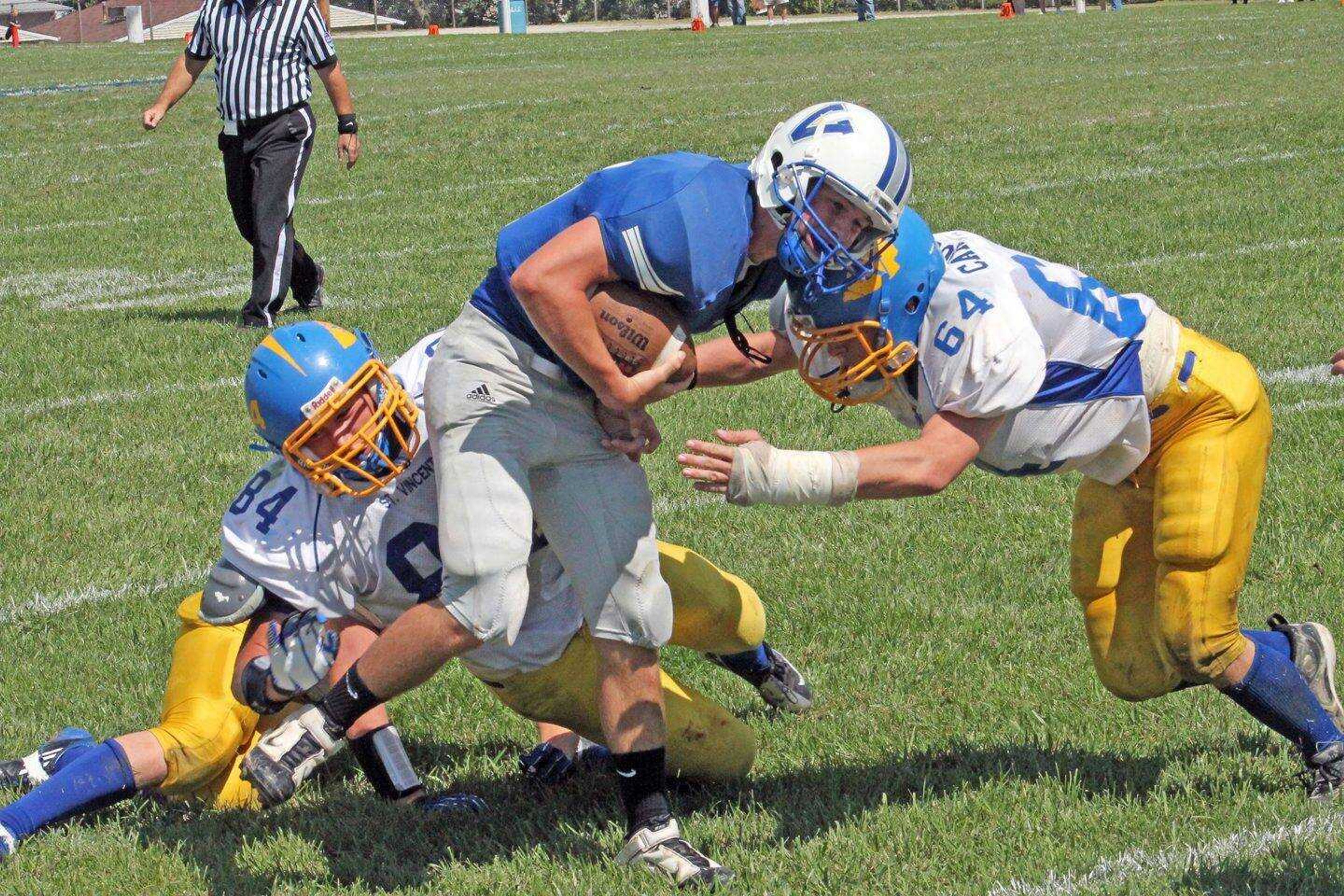 St. Vincent defensive end Kevin Mattingly (84) and defensive lineman Lucas Carroll (64) tackle Valle Catholic's Nolan Wood on a punt return during the fourth quarter Saturday at Valle Catholic High School in Ste. Genevieve, Mo. (MICHAEL BOYD ~ The Ste. Genevieve Herald)