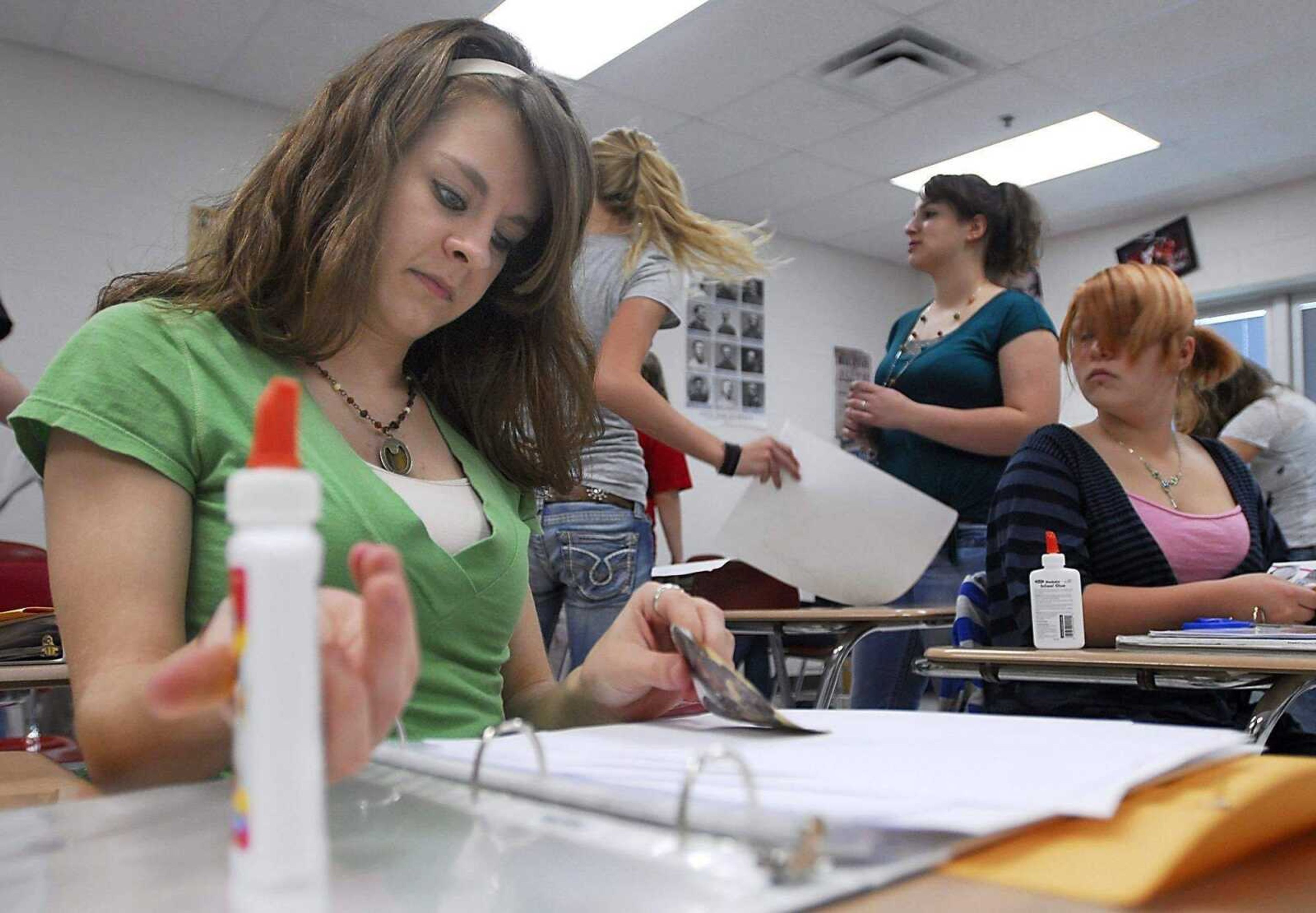 KIT DOYLE ~ kdoyle@semissourian.com<br>Hannah Nickelson, 15, glues a photo in her memory book March 17 in Jeff Scott's class at Jackson Junior High School.