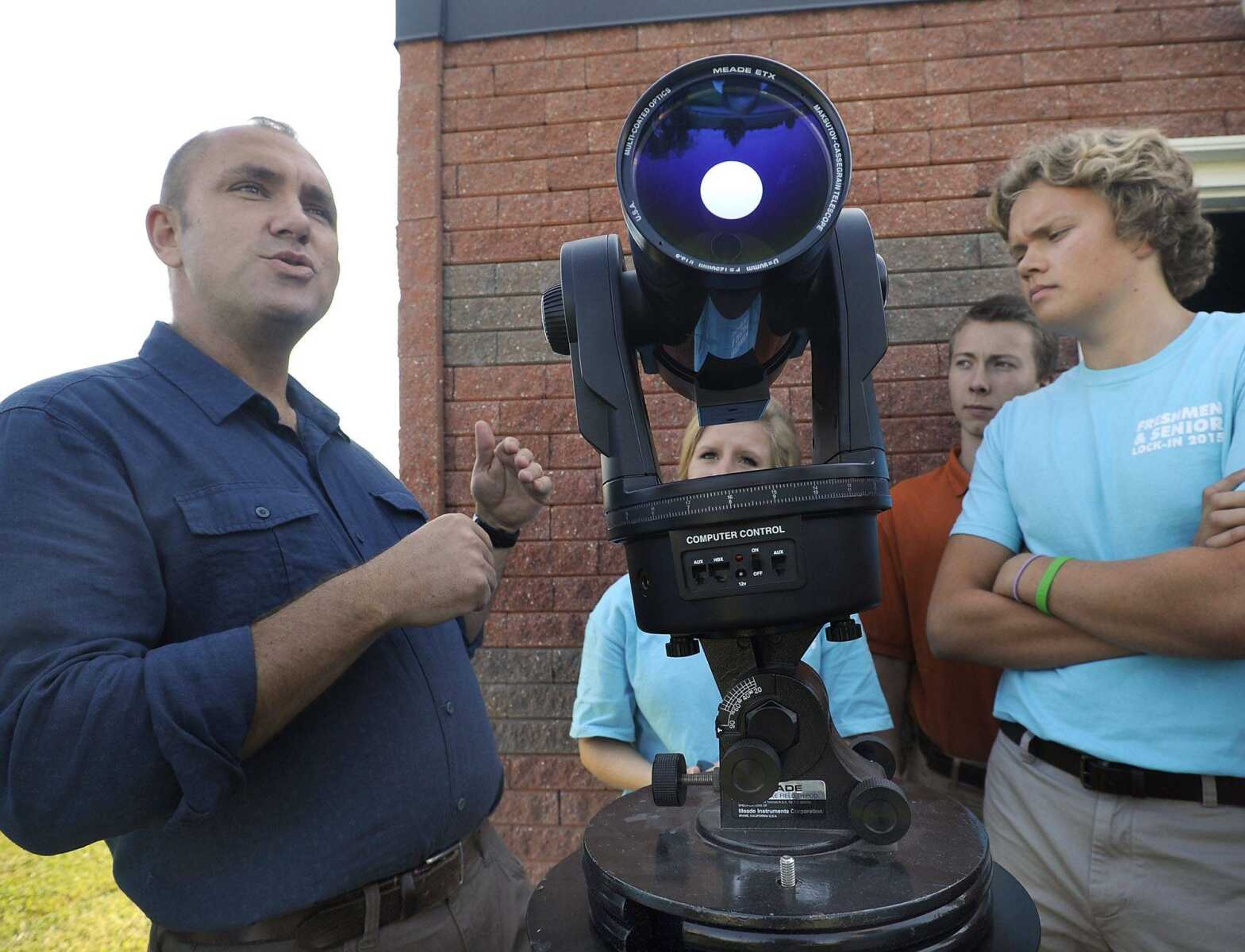 Science teacher Jerry Landewe, left, shows a tracking telescope to his senior astronomy class, as Evan Unterreiner looks on Aug. 24 at Notre Dame Regional High School. (Fred Lynch)