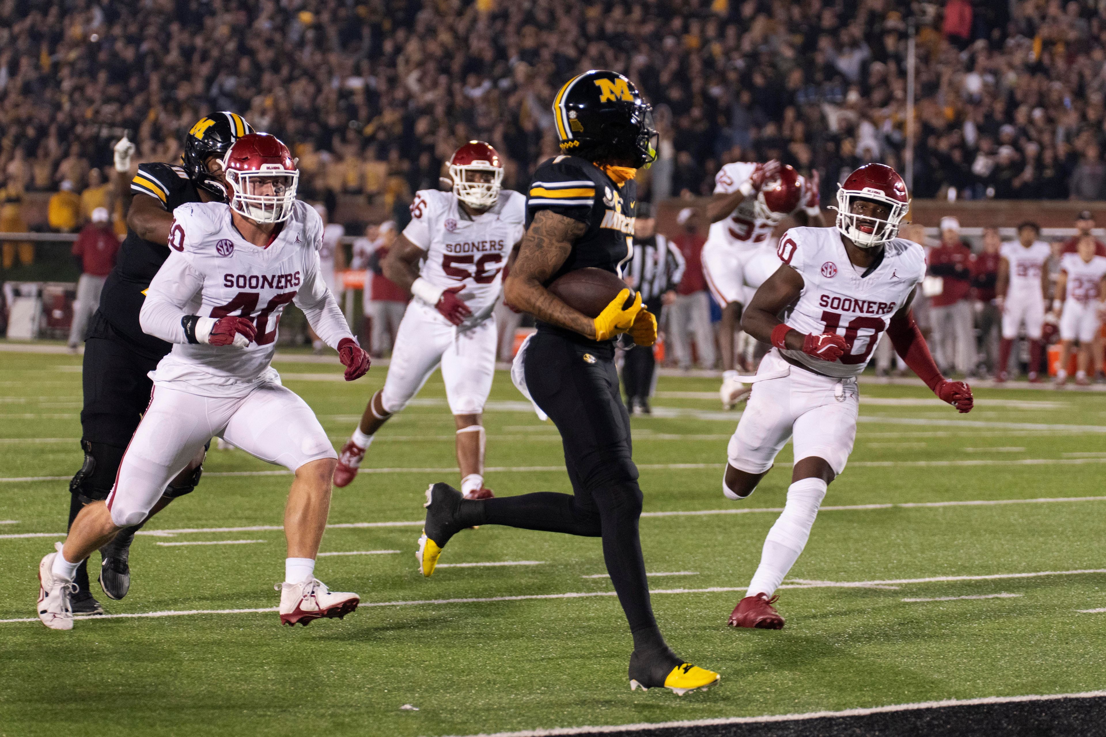 Missouri wide receiver Theo Wease Jr. looks back at Oklahoma's Kip Lewis (10), Ethan Downs, left, and Gracen Halton (56) as he scores a touchdown during the second half of an NCAA college football game Saturday, Nov. 9, 2024, in Columbia, Mo. Missouri won 30-23. (AP Photo/L.G. Patterson)