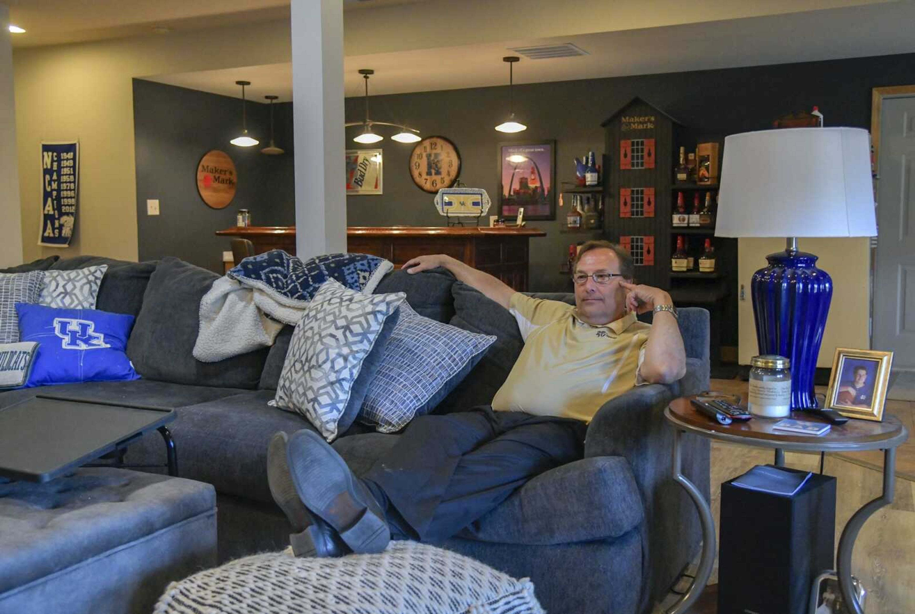 Mark Ruark relaxes on the couch in his man cave decorated with University of Kentucky and Maker's Mark items at his home in Cape Girardeau.