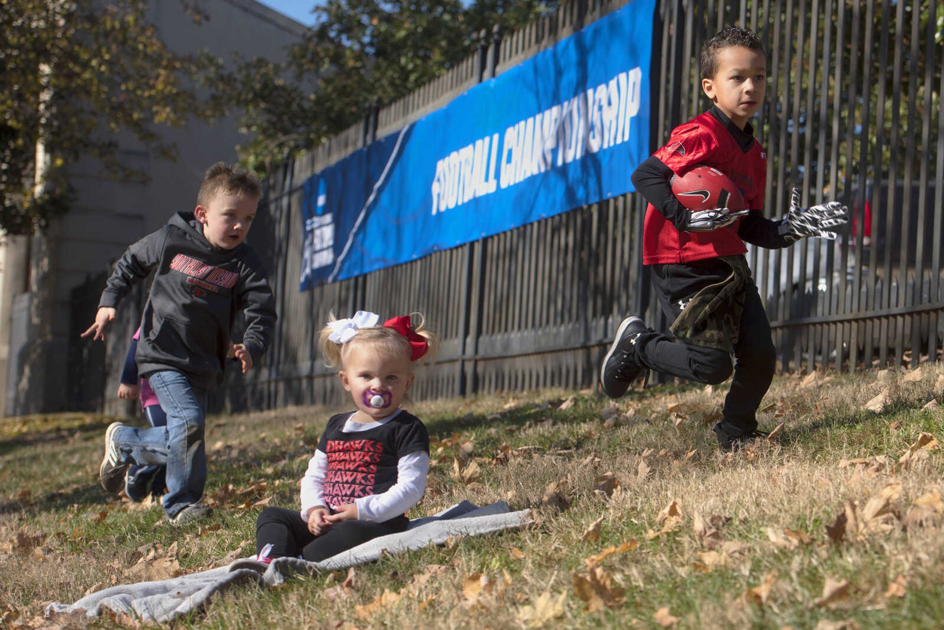 Jude Michel, 5, far left, chases Jett Hubbard, 4, far right, as Ronnie Kate Michel sits on the lawn Saturday, Nov. 24, 2018, outside Houck Stadium in Cape Girardeau.