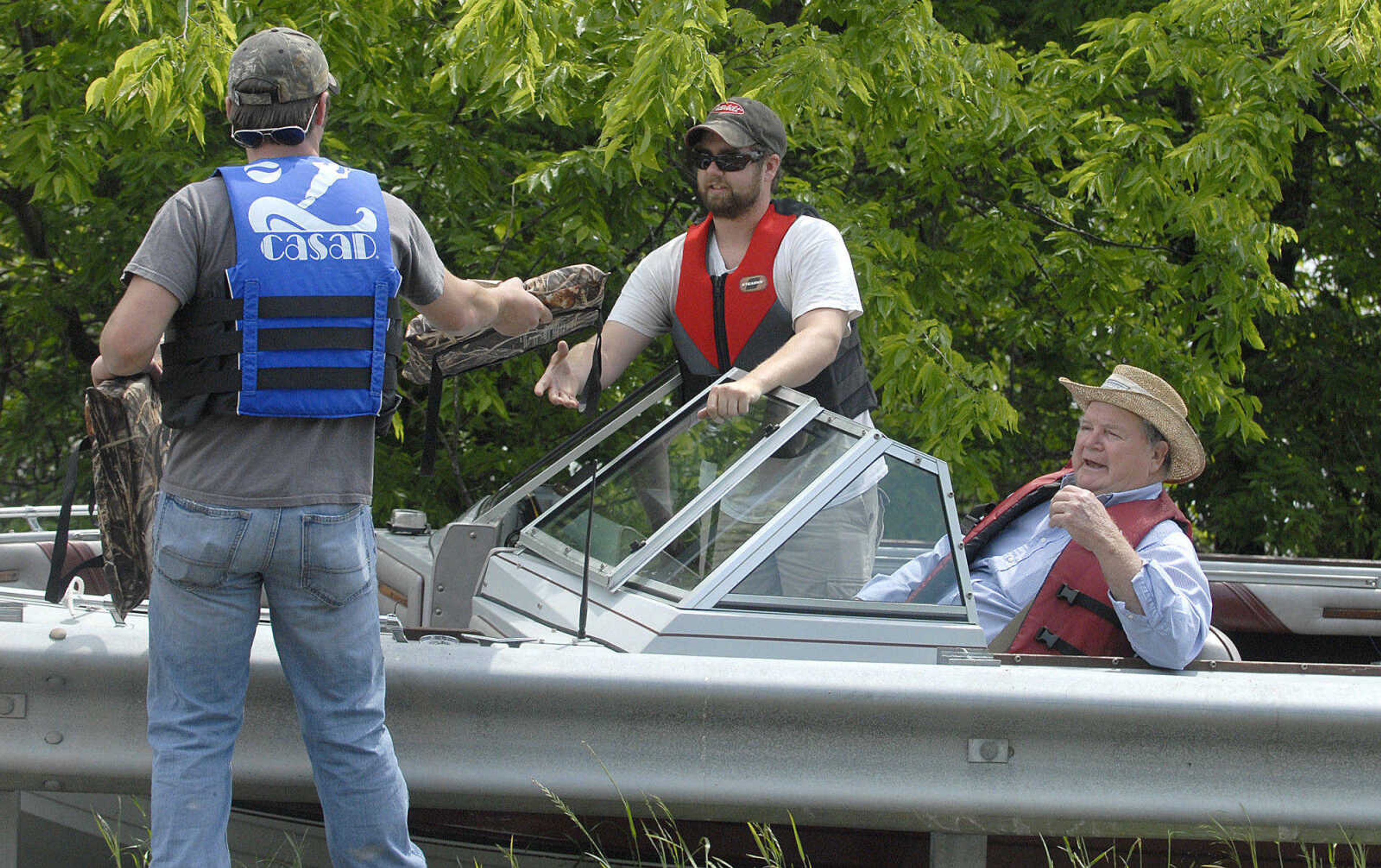 LAURA SIMON~lsimon@semissourian.com
Chris Byasse hands Eric Thomure a life jacket before setting off for his grandfather Claude Thomure's property Monday, May 9, 2011 in the Mississippi County floodway.