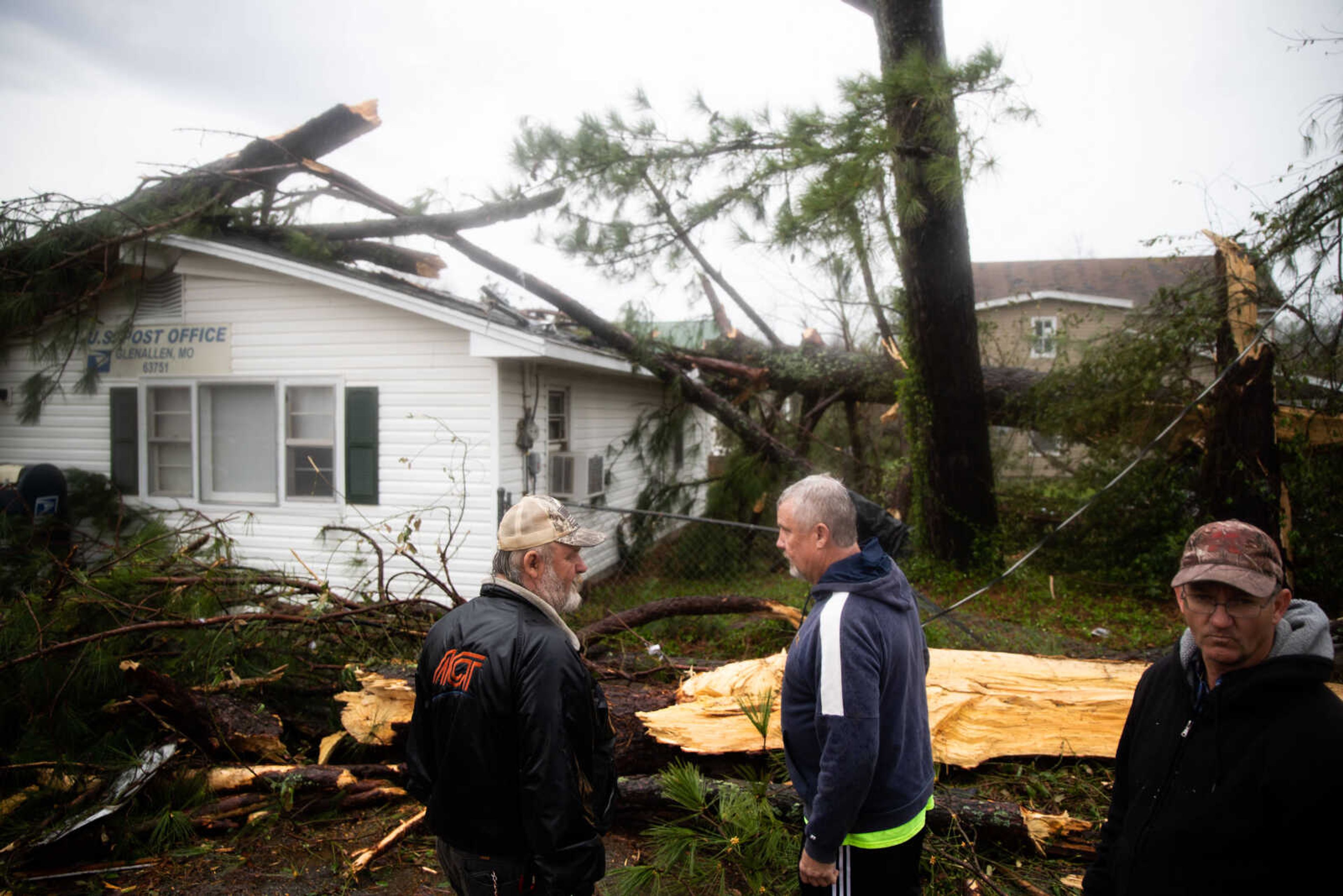 Community members prepare to remove a tree from the roof of the Glen Allen Post Office.