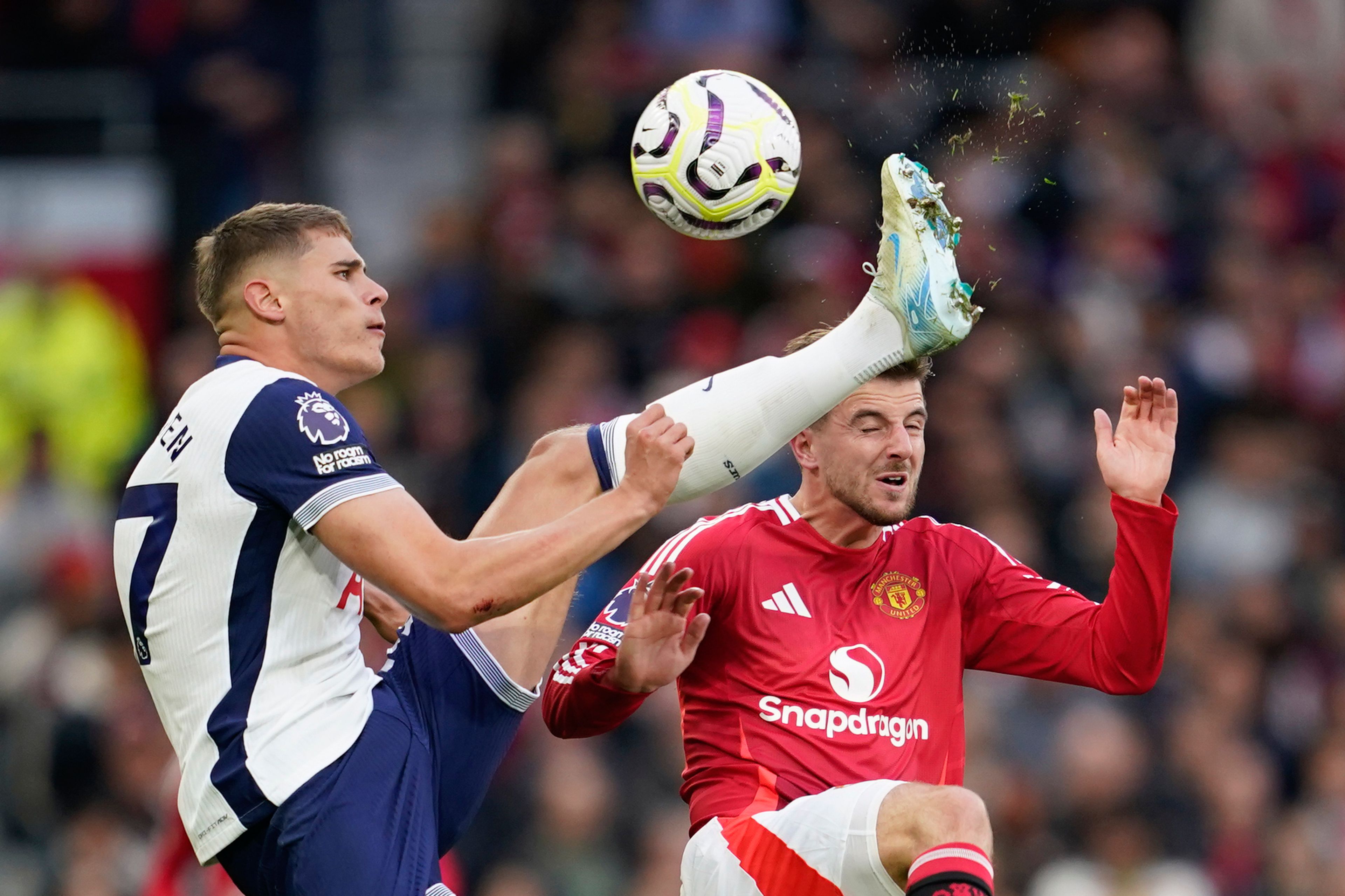 Tottenham's Micky van de Ven, left, challenges for the ball with Manchester United's Mason Mount during the English Premier League soccer match between Manchester United and Tottenham Hotspur at Old Trafford stadium in Manchester, England, Sunday, Sept. 29, 2024. (AP Photo/Dave Thompson)