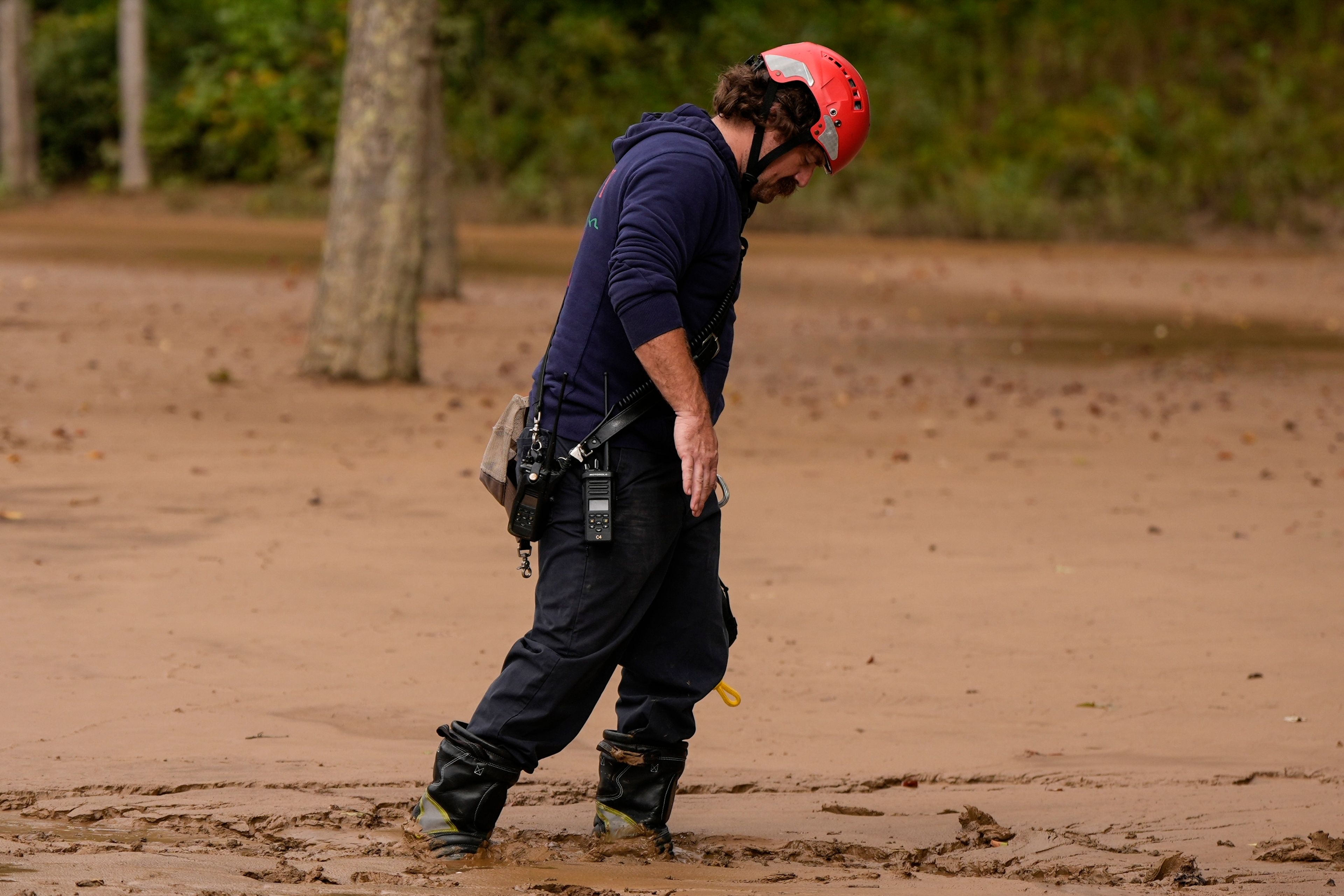 FILE - A fireman walks through mud as they search for victims of flooding in the aftermath of Hurricane Helene, Oct. 1, 2024, in Swannanoa, N.C. (AP Photo/Mike Stewart, File)