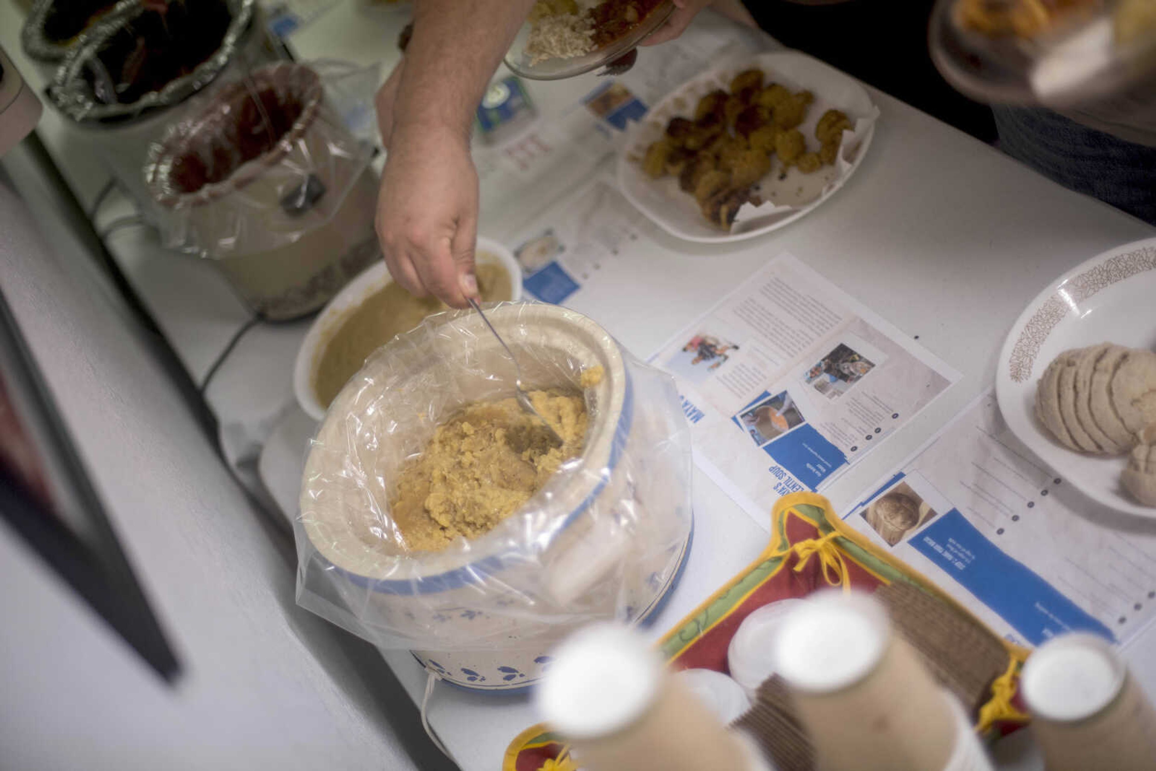 A guest tries hummus at the buffet table Wednesday, June 19, 2019, at Cape Girardeau in Abbey Road Christian Church.