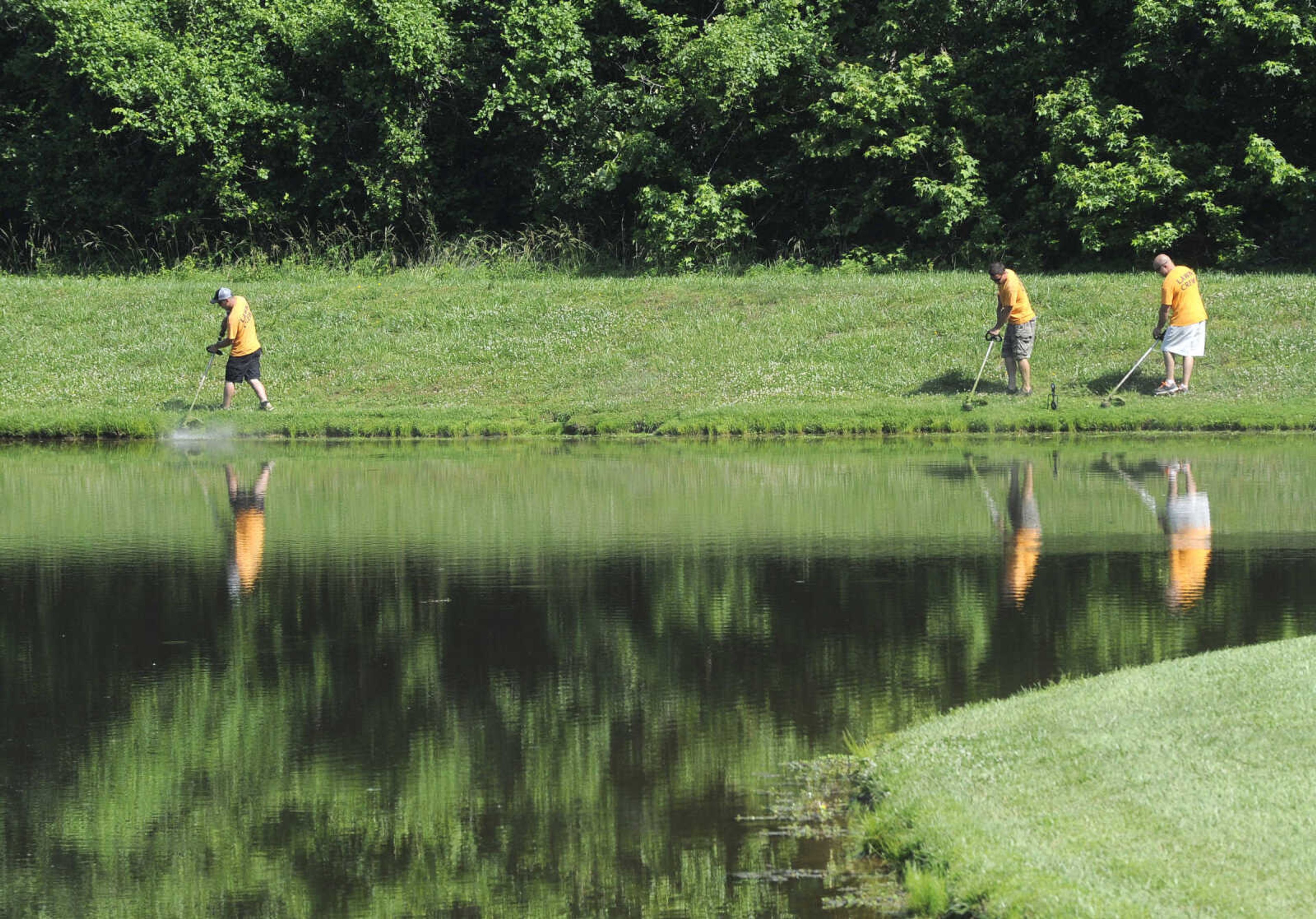 FRED LYNCH ~ flynch@semissourian.com
A lawn crew with Adult and Teen Challenge Mid-America trims around a lake Saturday, June 3, 2017 in Cape Girardeau.