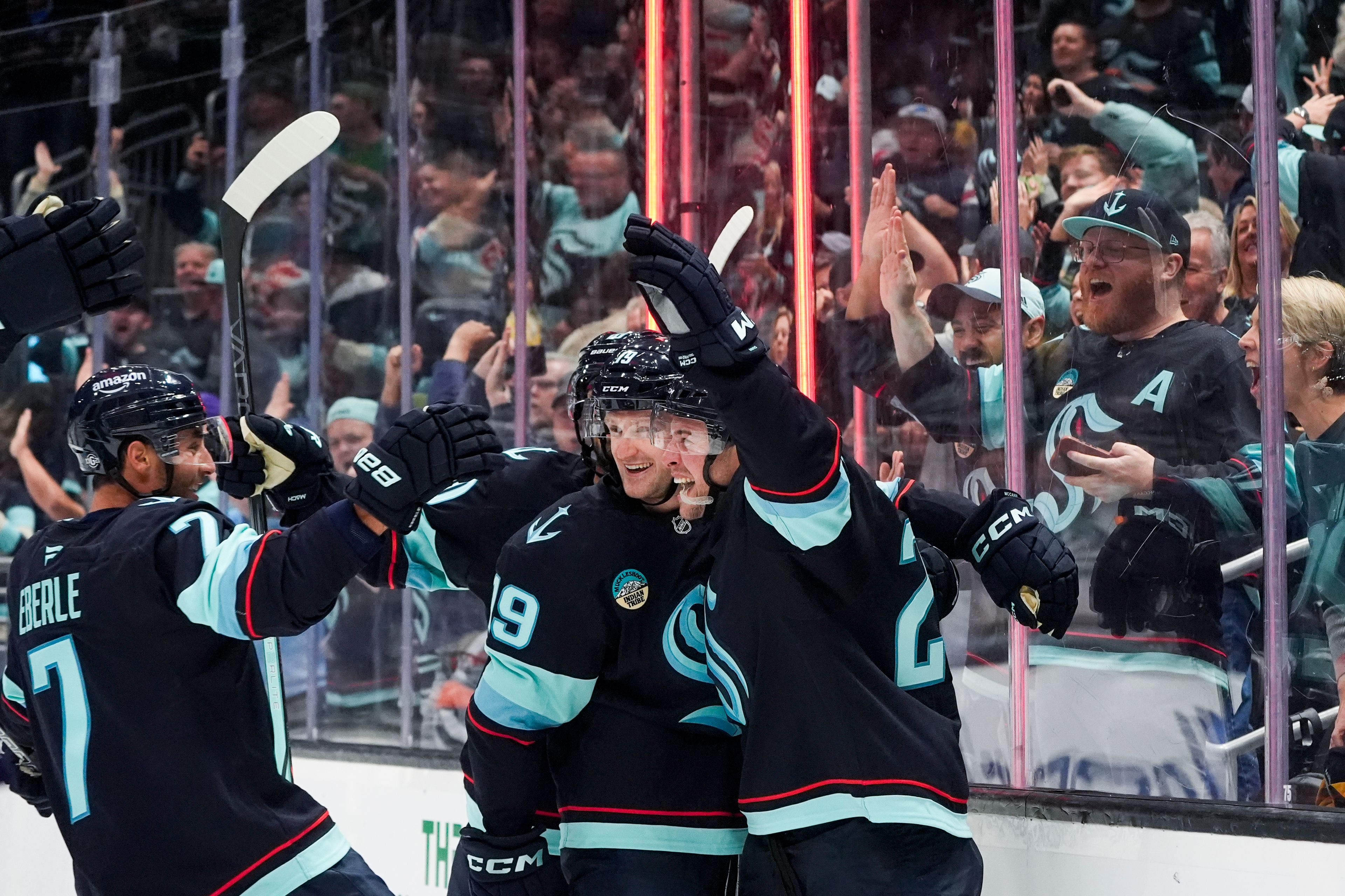 Seattle Kraken defenseman Vince Dunn, right, celebrates his goal with left wing Jared McCann (19) and right wing Jordan Eberle (7) during the second period of an NHL hockey game Tuesday, Oct. 8, 2024, in Seattle. (AP Photo/Lindsey Wasson)