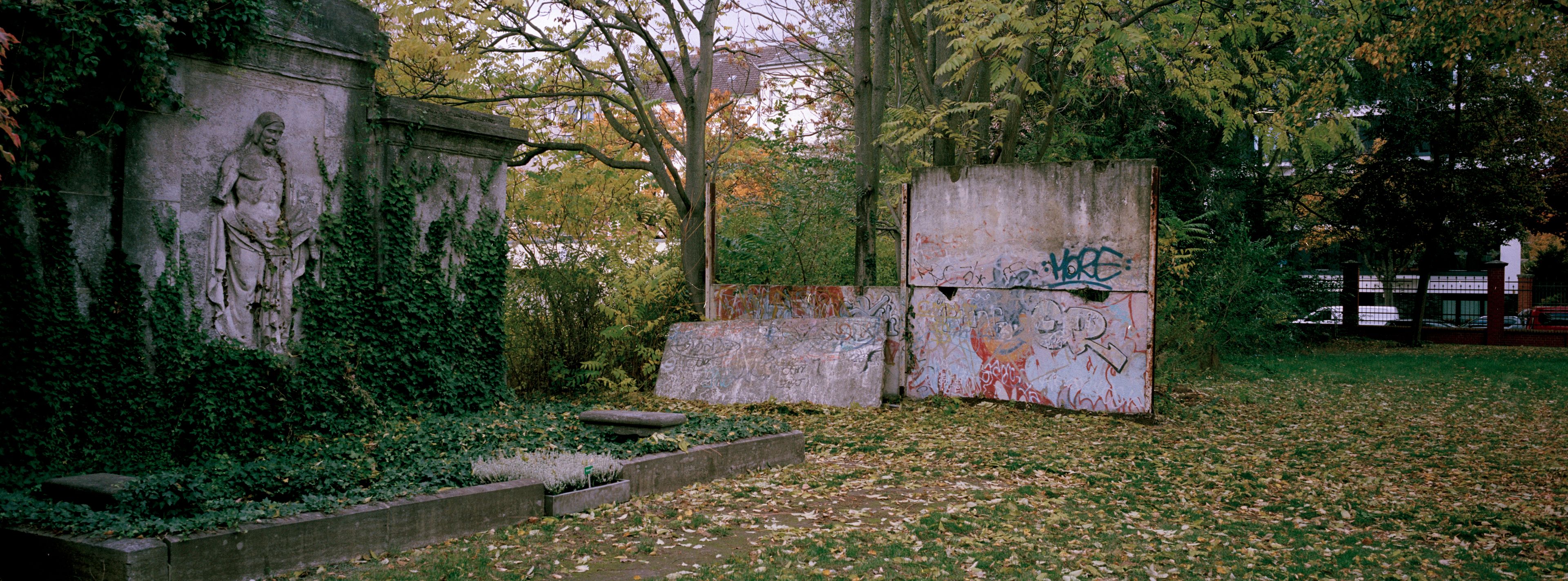 Remains of the Berlin Wall stand next to graves on a cemetery in Central Berlin, Germany, Tuesday, Oct. 22, 2024. (AP Photo/Markus Schreiber)