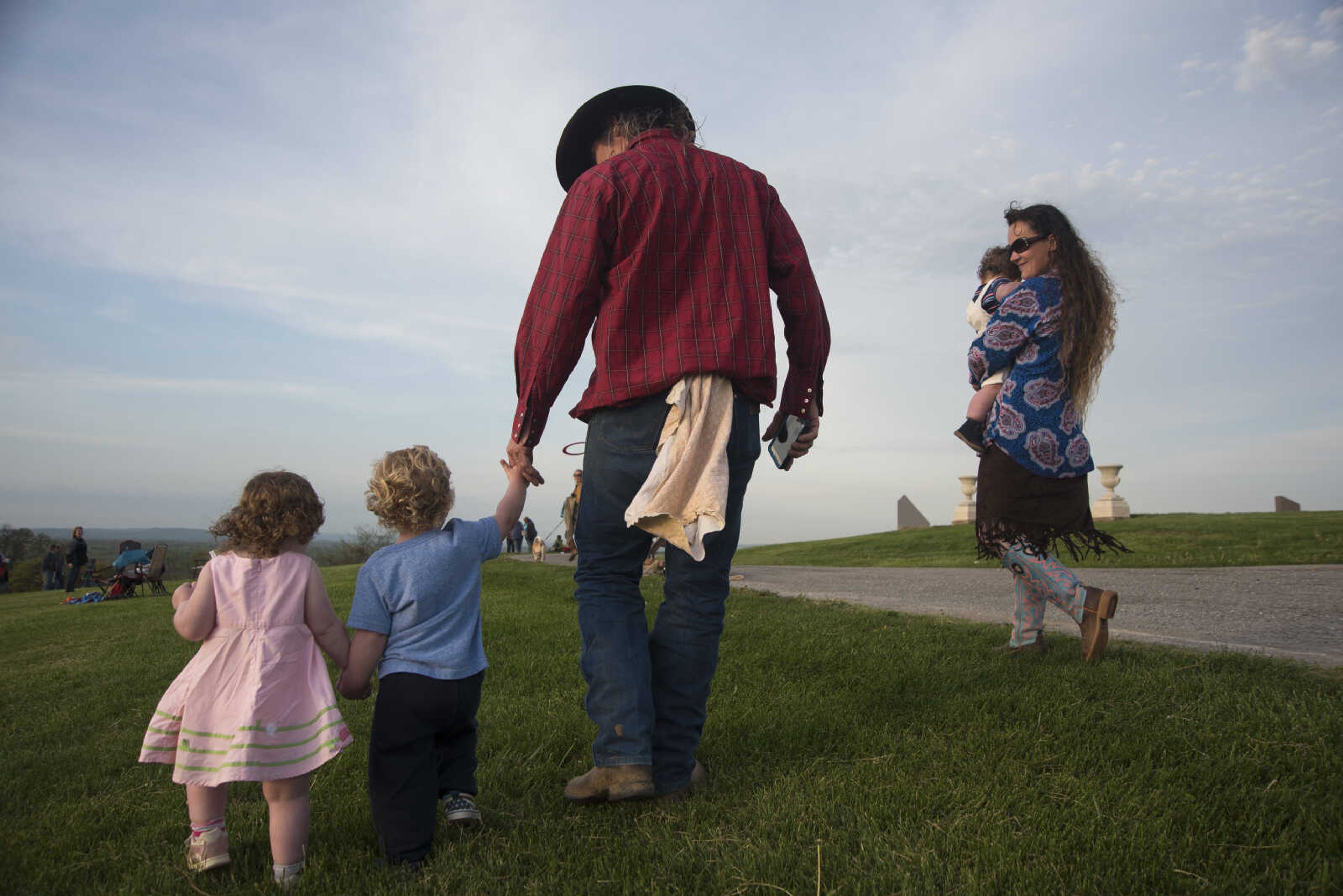 Chris Powers holding hands with Noah Gilliland and Amelia Gilliland with Katie Powers holding Dallas Gilliland walk away after attending the 81st annual Easter Sunrise Service at the Bald Knob Cross of Peace Sunday, April 16, 2017 in Alto Pass, Illinois.