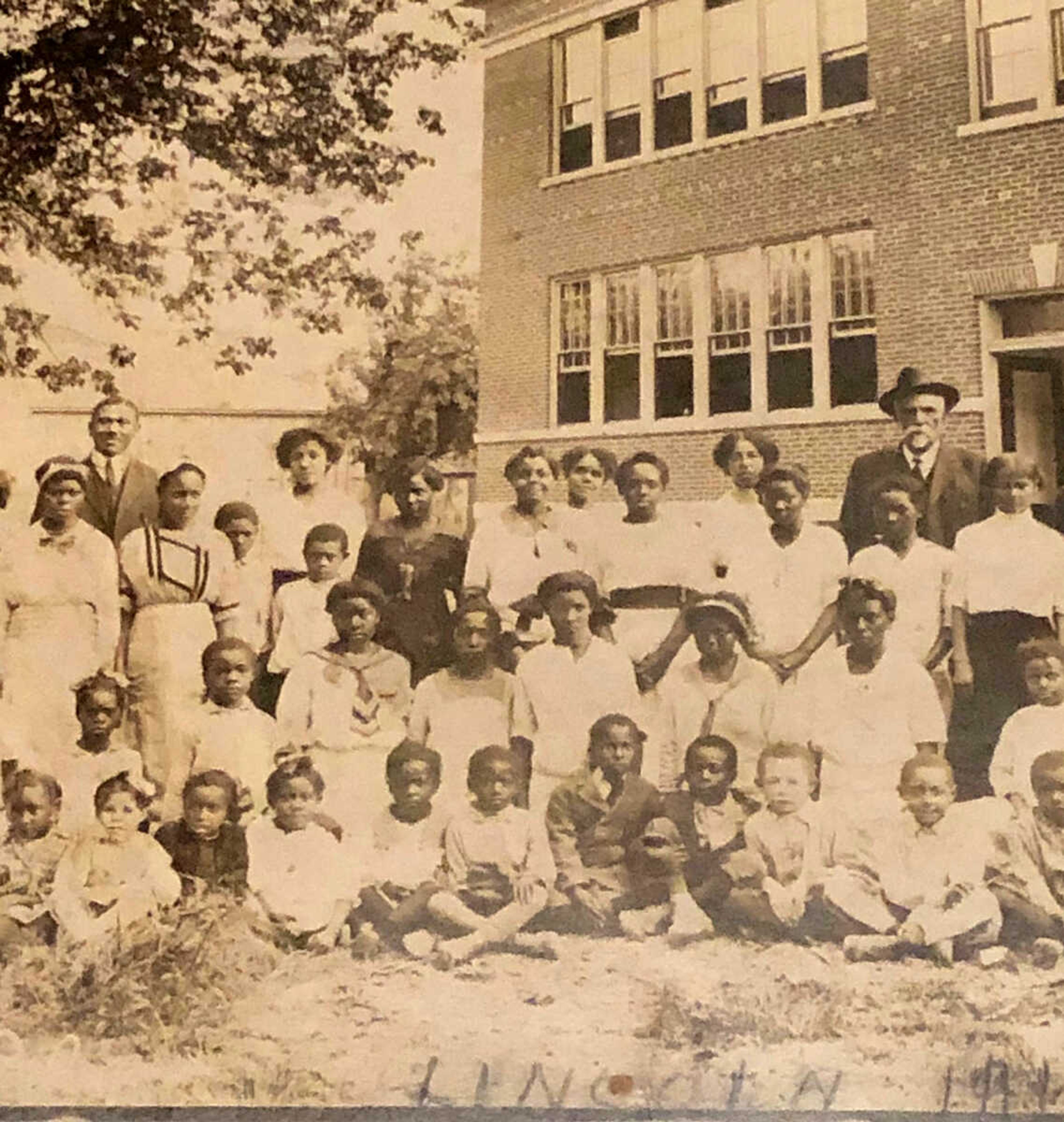 Professor John S. Cobb (the gentleman in hat and suit, to the right) stands with a group of his students and teachers at Lincoln School, 731 Merriwether St. in Cape Girardeau, circa 1914. Professor O.O.Nance, Cobb's successor as principal of the school, is to the left in the photo. This clipped closeup view is from a larger panorama photo, which depicts 195 individuals of the school family of students (elementary through high school) with their dedicated teachers.