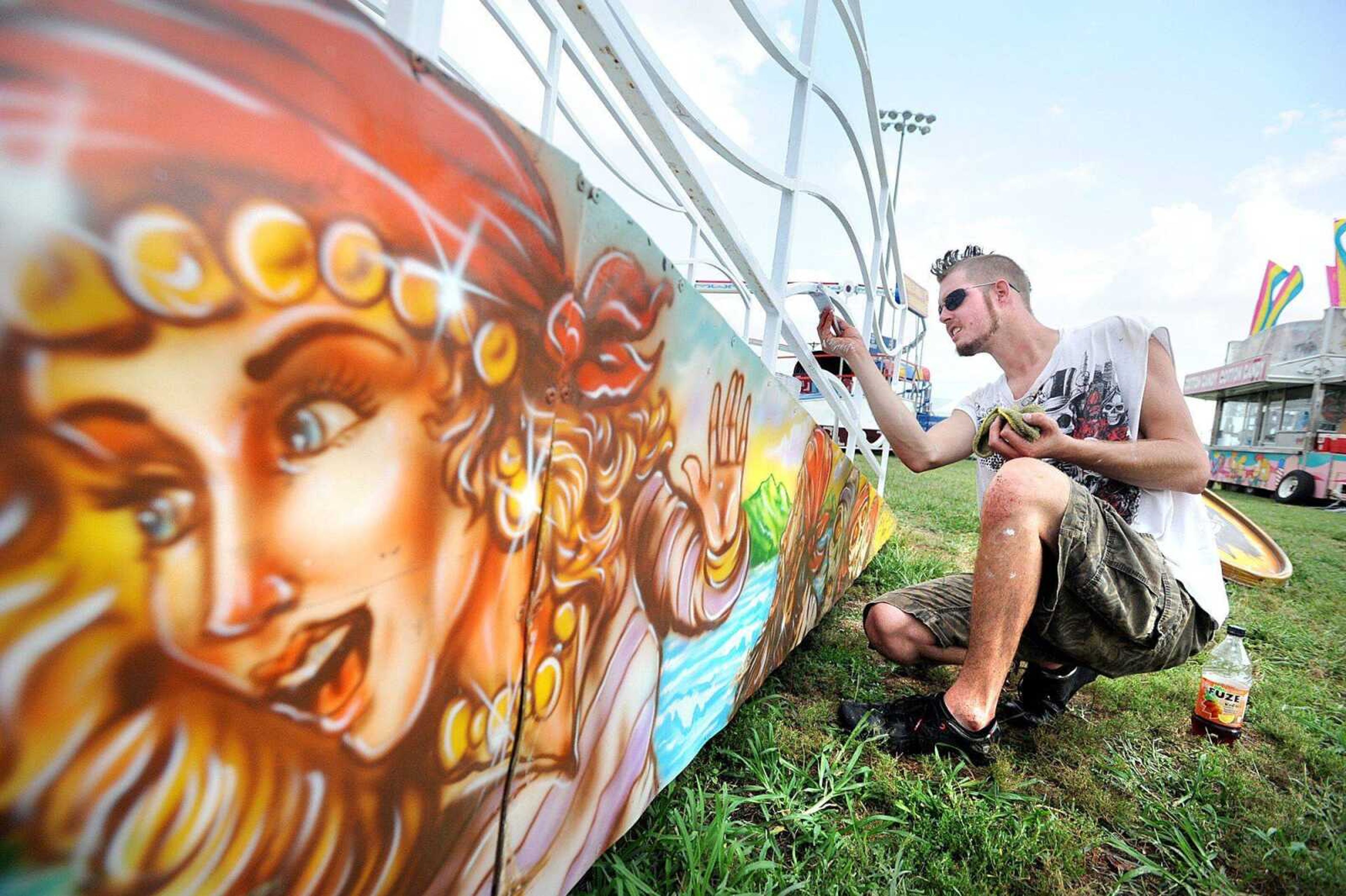 Jimmy Wilkinson with Lowery Carnival Co. applies a fresh coat of white paint to the railing of the Sea Dragon ride Wednesday at Arena Park in Cape Girardeau. The SEMO District Fair kicks off Saturday with the antique tractor pull in the morning, carnival armbands and the hotrod truck and tractor pull in the evening. (Laura Simon)