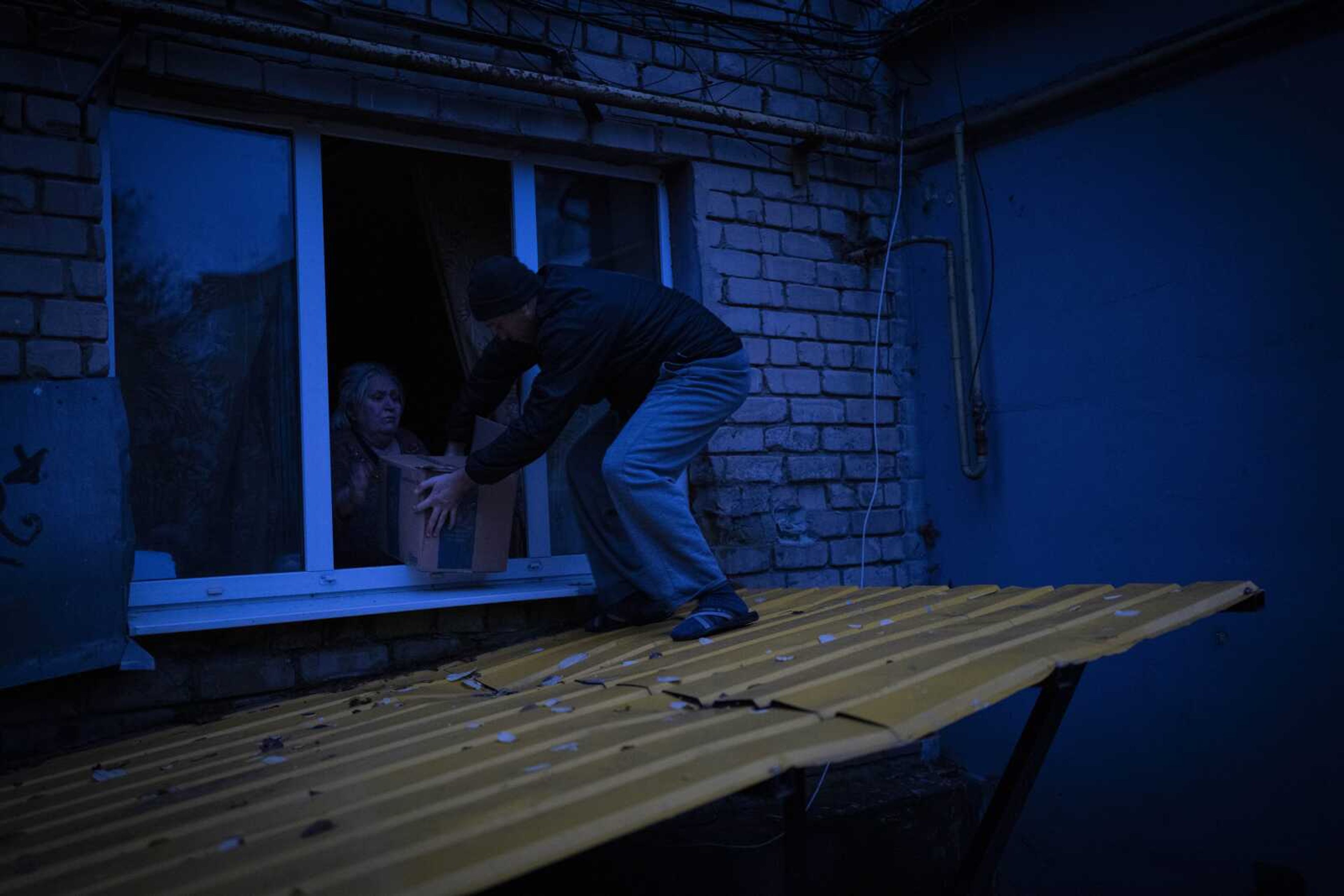 An elderly resident, who preferred not to be evacuated from the southern city of Kherson, receives a food donation from a local organization Sunday, Nov. 27, in Ukraine.