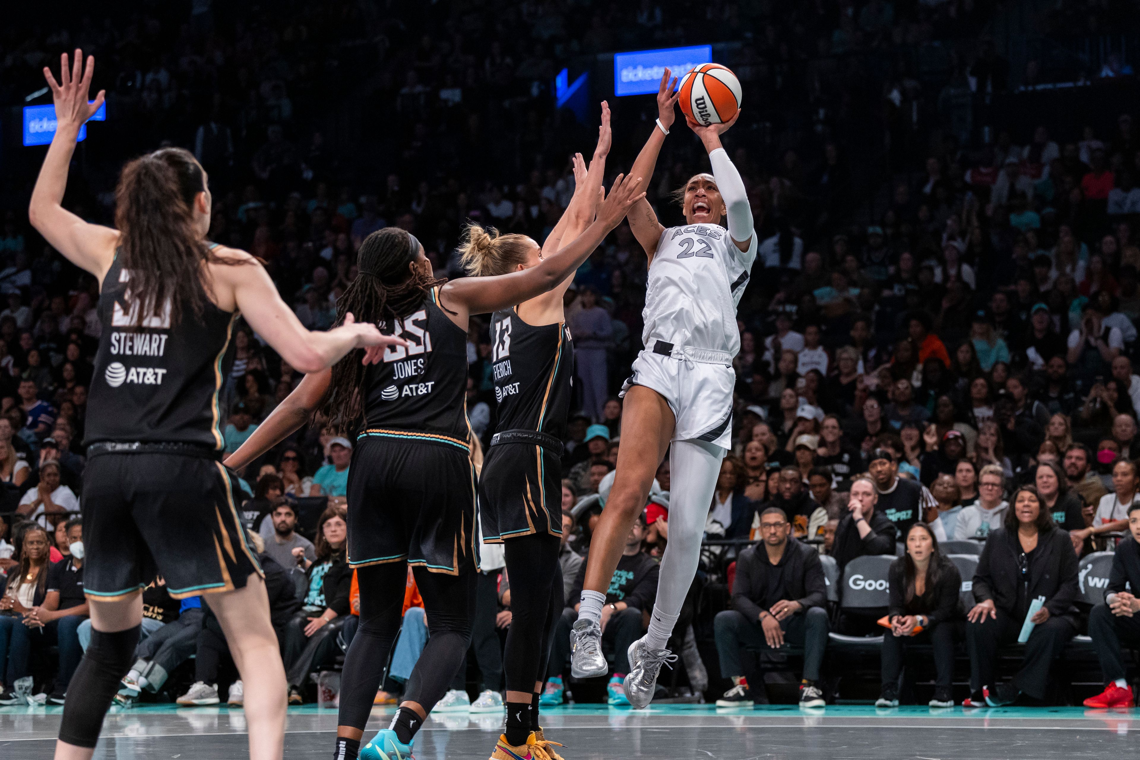 Las Vegas Aces center A'ja Wilson (22) shoots over New York Liberty forward Leonie Fiebich (13) as forward Breanna Stewart (30) and forward Jonquel Jones (35) defend during the second half of a WNBA basketball second-round playoff game, Sunday, Sept. 29, 2024, in New York. (AP Photo/Corey Sipkin)