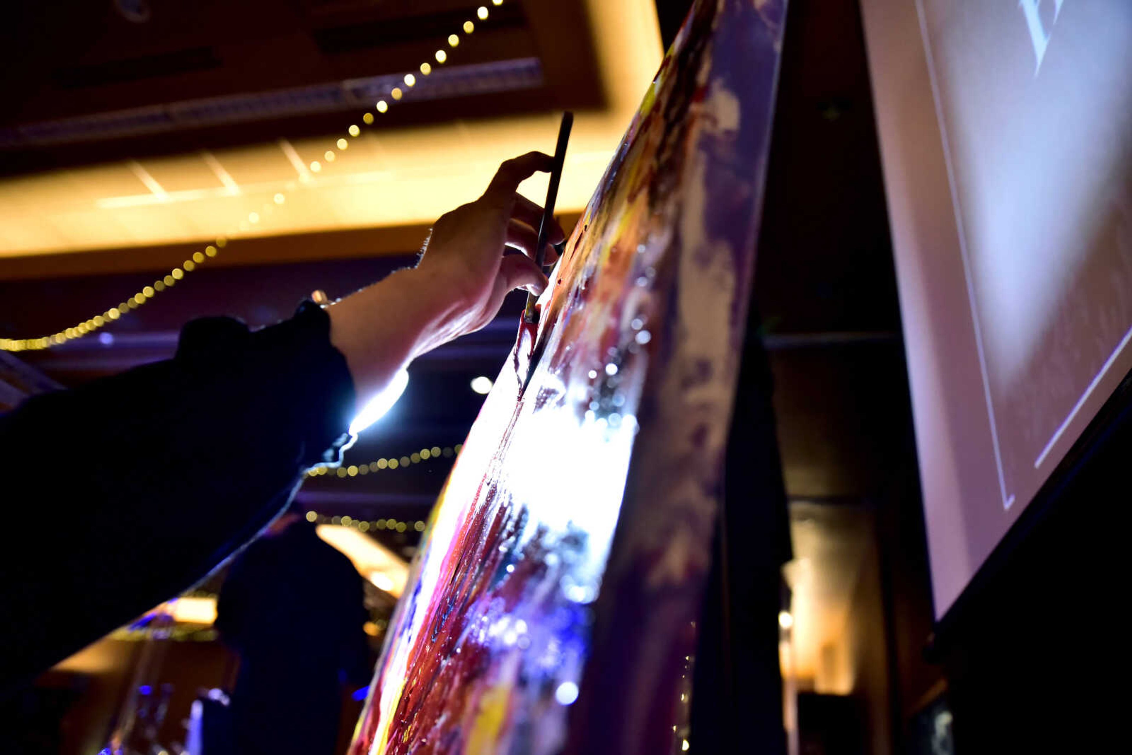 Rosetta Whitten, a local artist, paints at the third annual Friends of Saint Francis Gala held at the Isle Casino on March 3, 2018, in Cape Girardeau. Whitten said she does "collaborative paint events" where she asks the guests to get involved with the painting throughout the night.