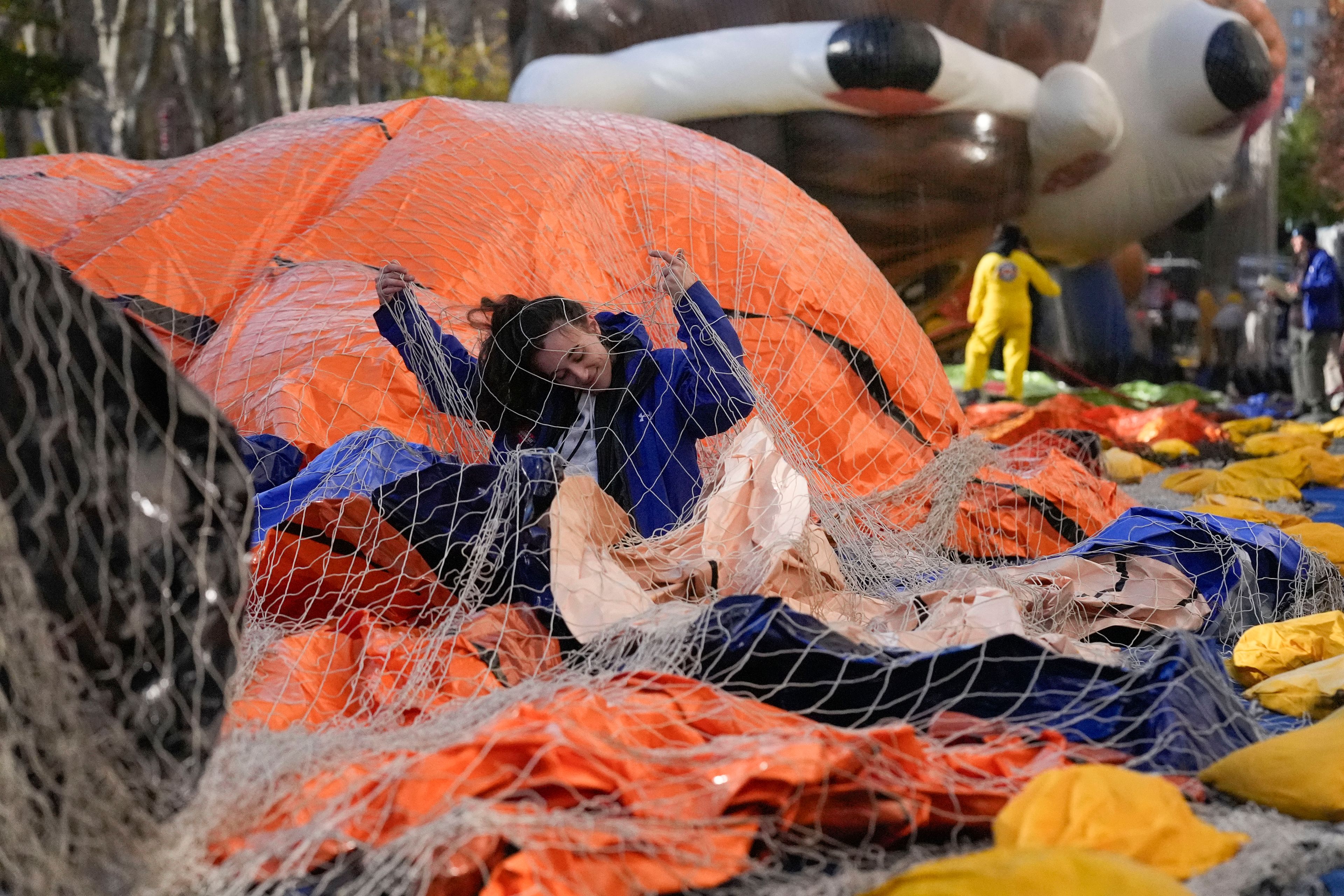 Ash Ditaranto tries to disentangle herself from a net after helping to inflate a float in preparation for the Macy's Thanksgiving Day Parade in New York, Wednesday, Nov. 27, 2024. (AP Photo/Seth Wenig)