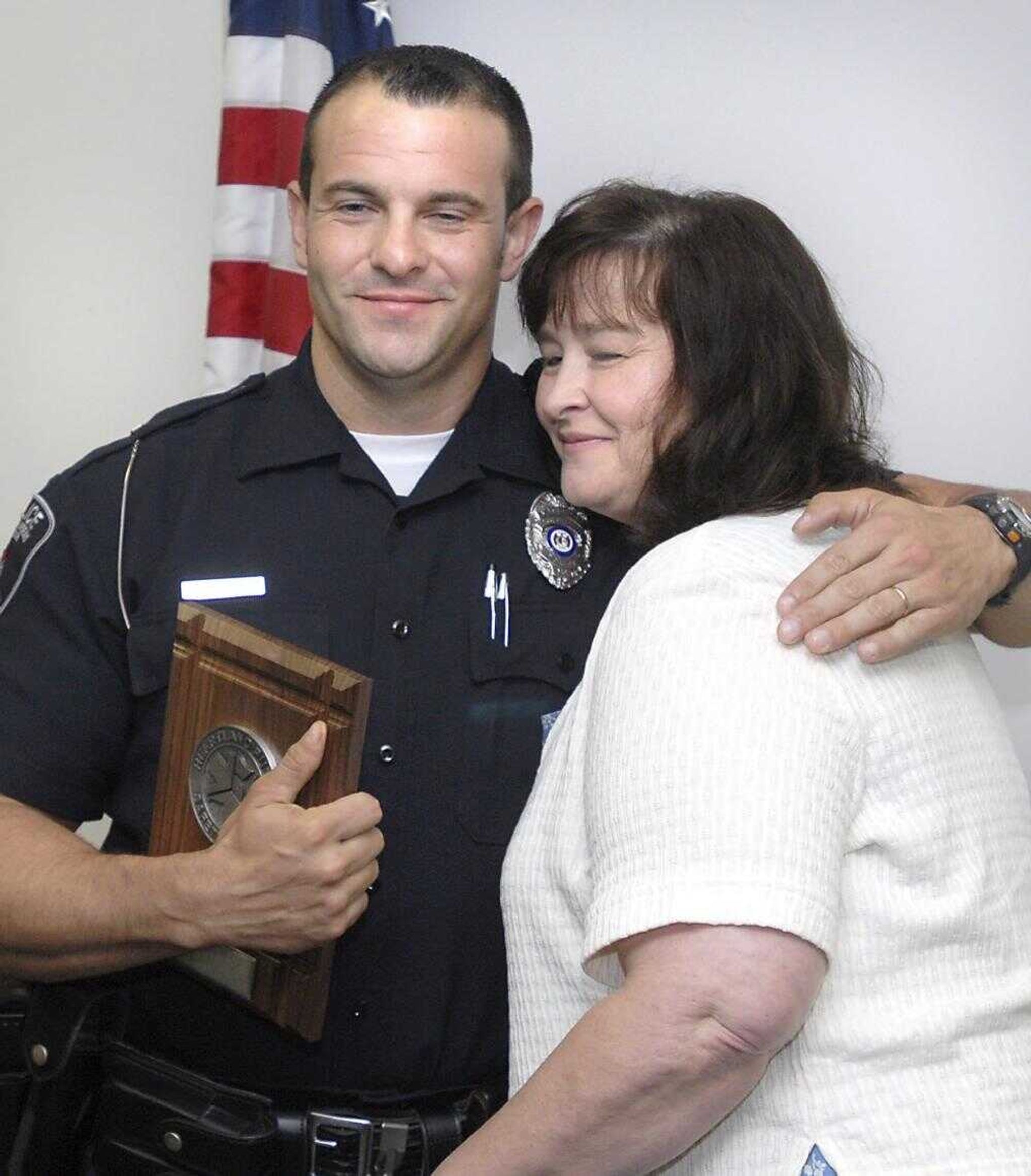 FRED LYNCH ~ flynch@semissourian.com (Kimberly Turnbough of Scott City presented Cape Girar~deau patrolman Joey Hann with the Law Enforcement Officer of the Year award from Heartland Public Safety Supply on Thursday. Hann was working for the Scott City Police Department when he rescued Turnbough from a burning house in August 2005.)