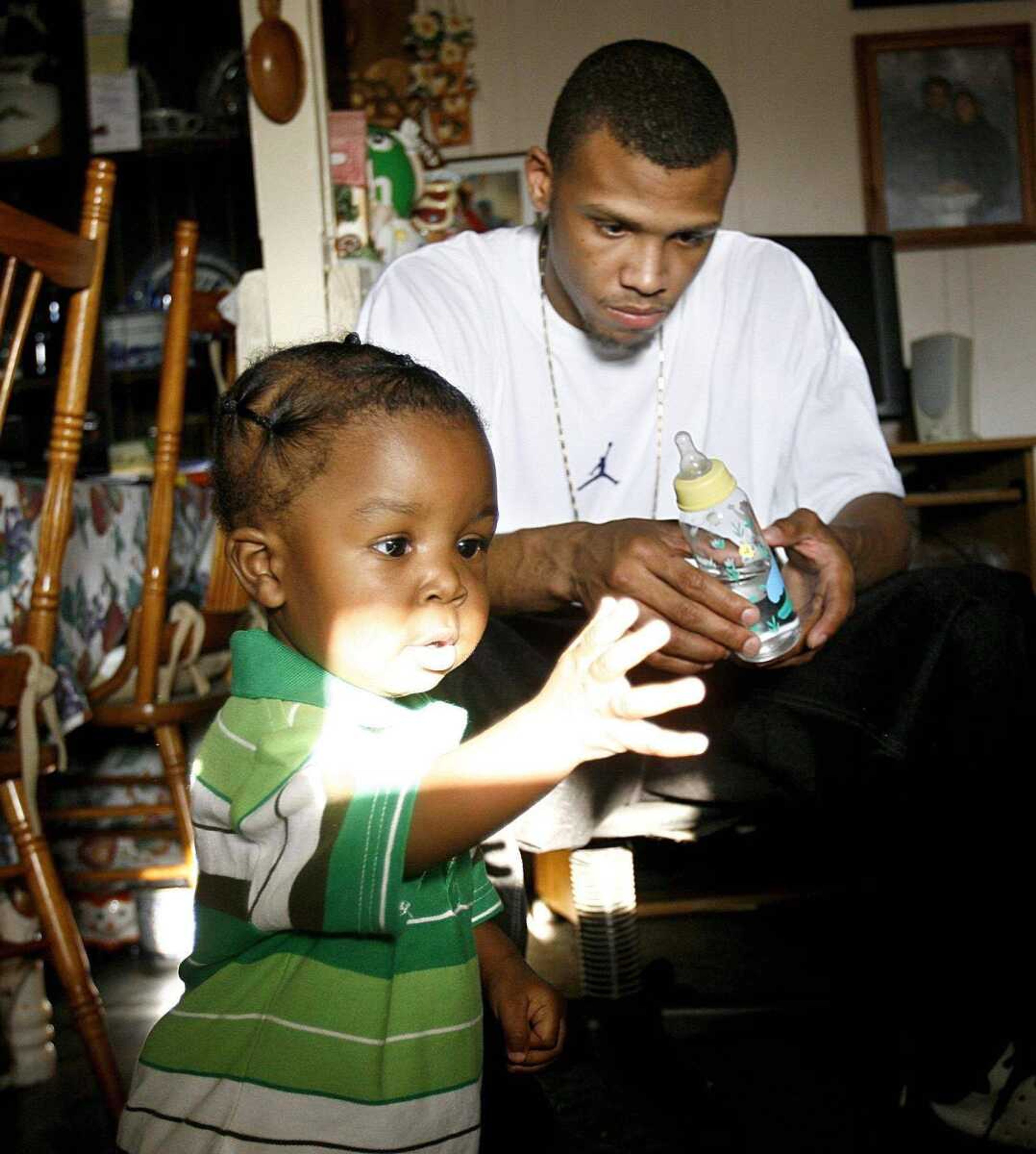 Kobe Thomas, 11 months, plays in the sunlight while visiting with his father, Drew Thomas, at his home Tuesday.