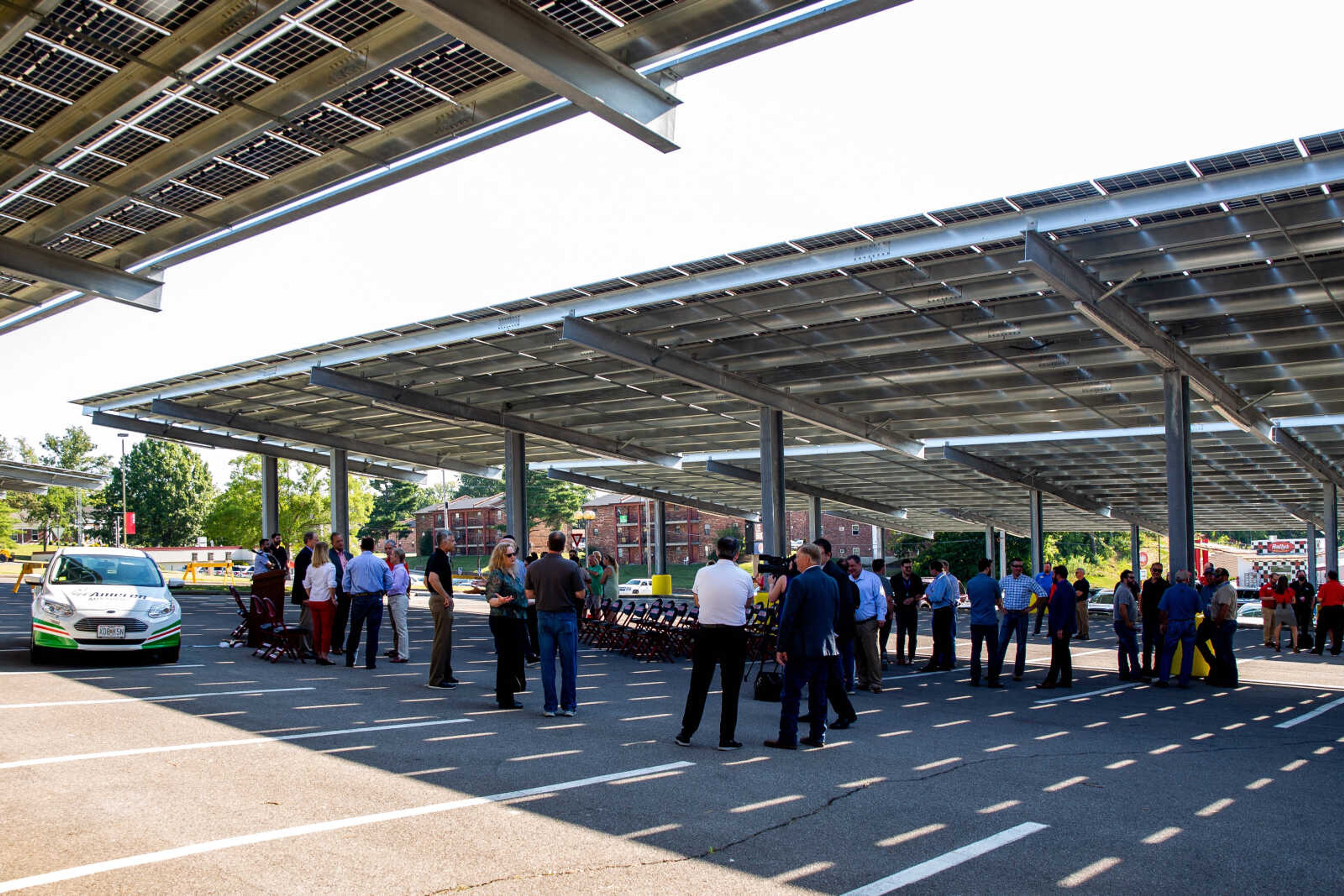 Members of the Cape Girardeau community gather in the shade cast by overhead solar panels, a recent Ameren Missouri project gifted to the university, at the Show Me Center parking lot on Thursday, Aug. 25.