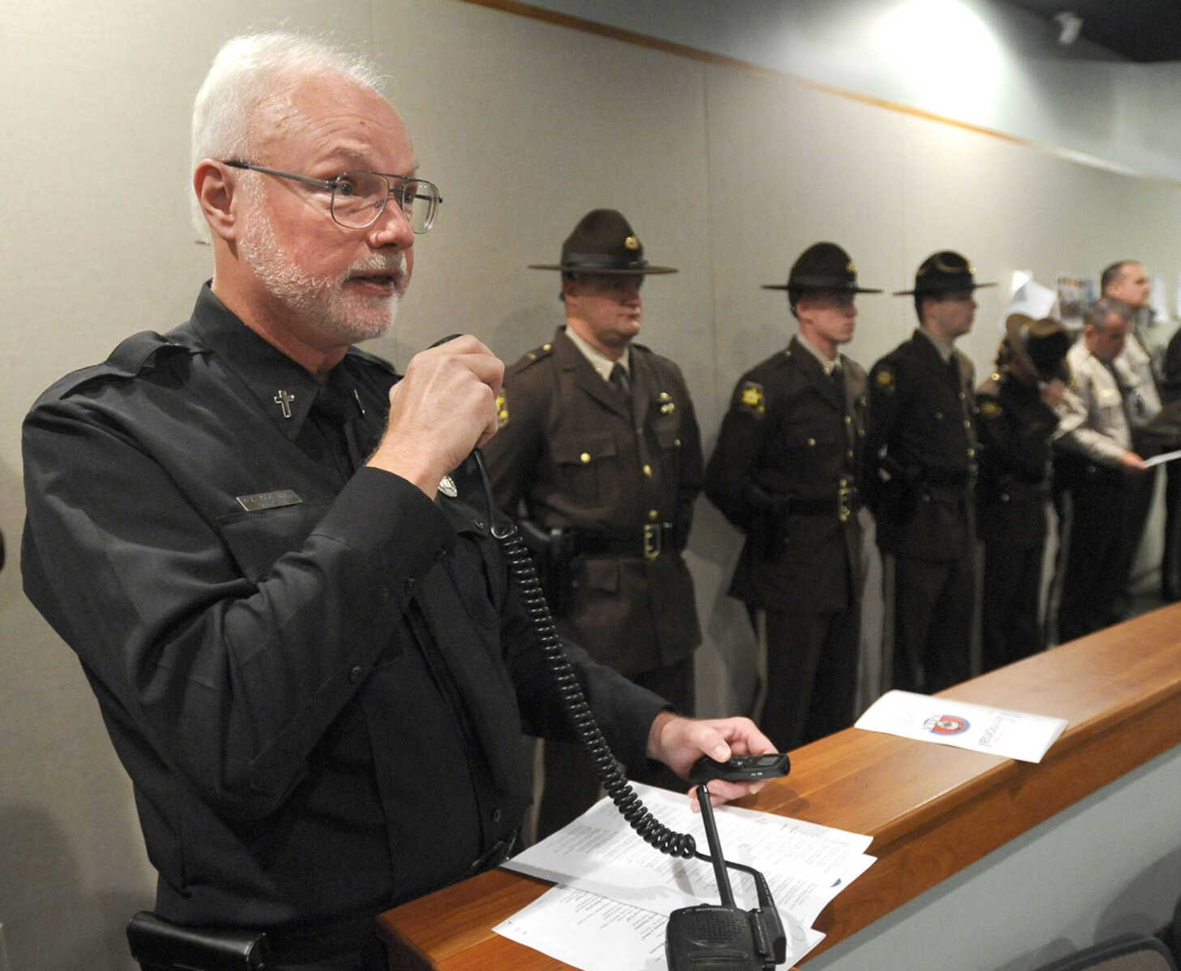 Chaplain John Harth conducts the final roll call of fallen personnel over the police radio.