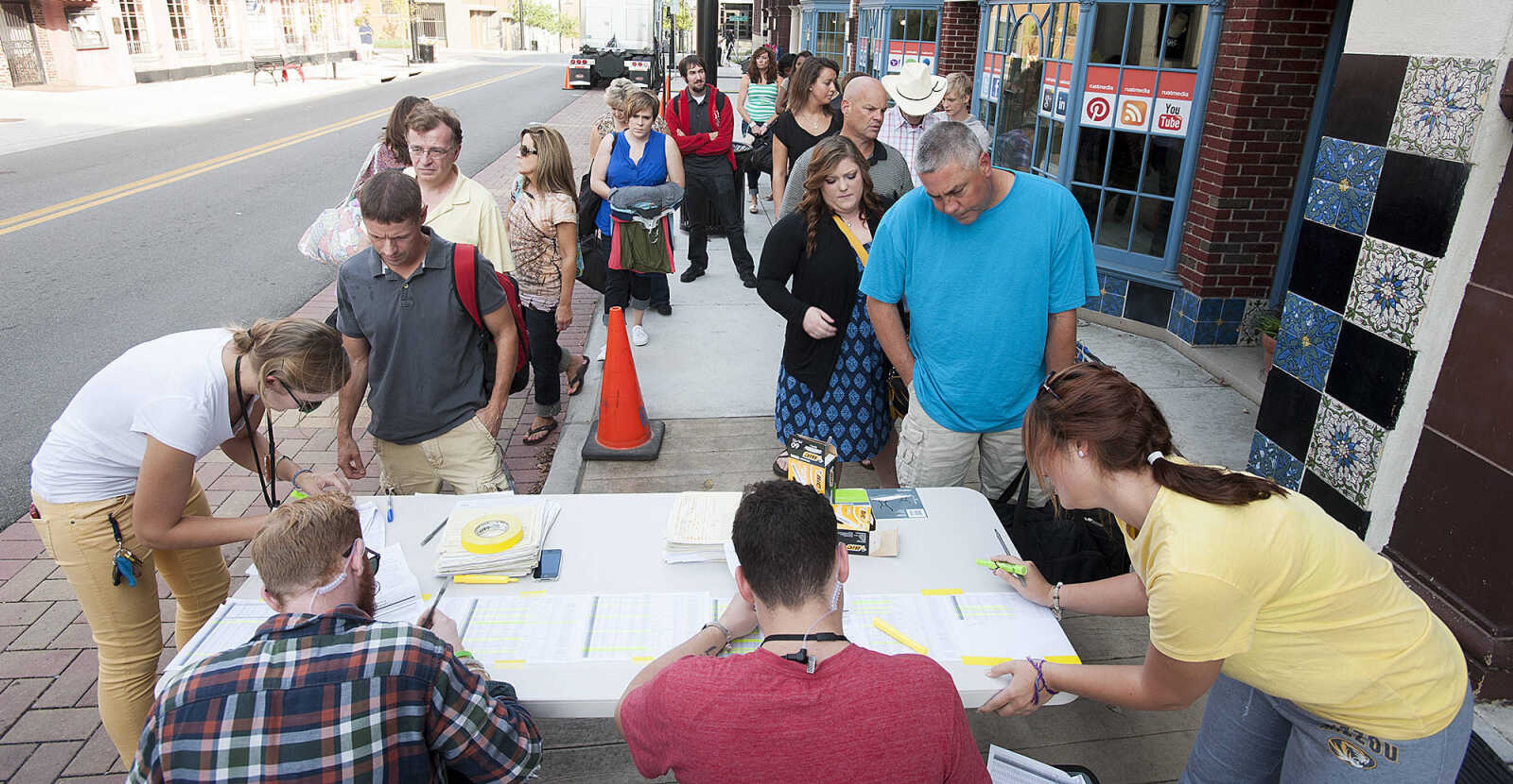 ADAM VOGLER ~ avogler@semissourian.com
Extras working on the 20th Century Fox feature film "Gone Girl," check in before filming a sceneThursday, Oct. 3, in downtown Cape Girardeau.