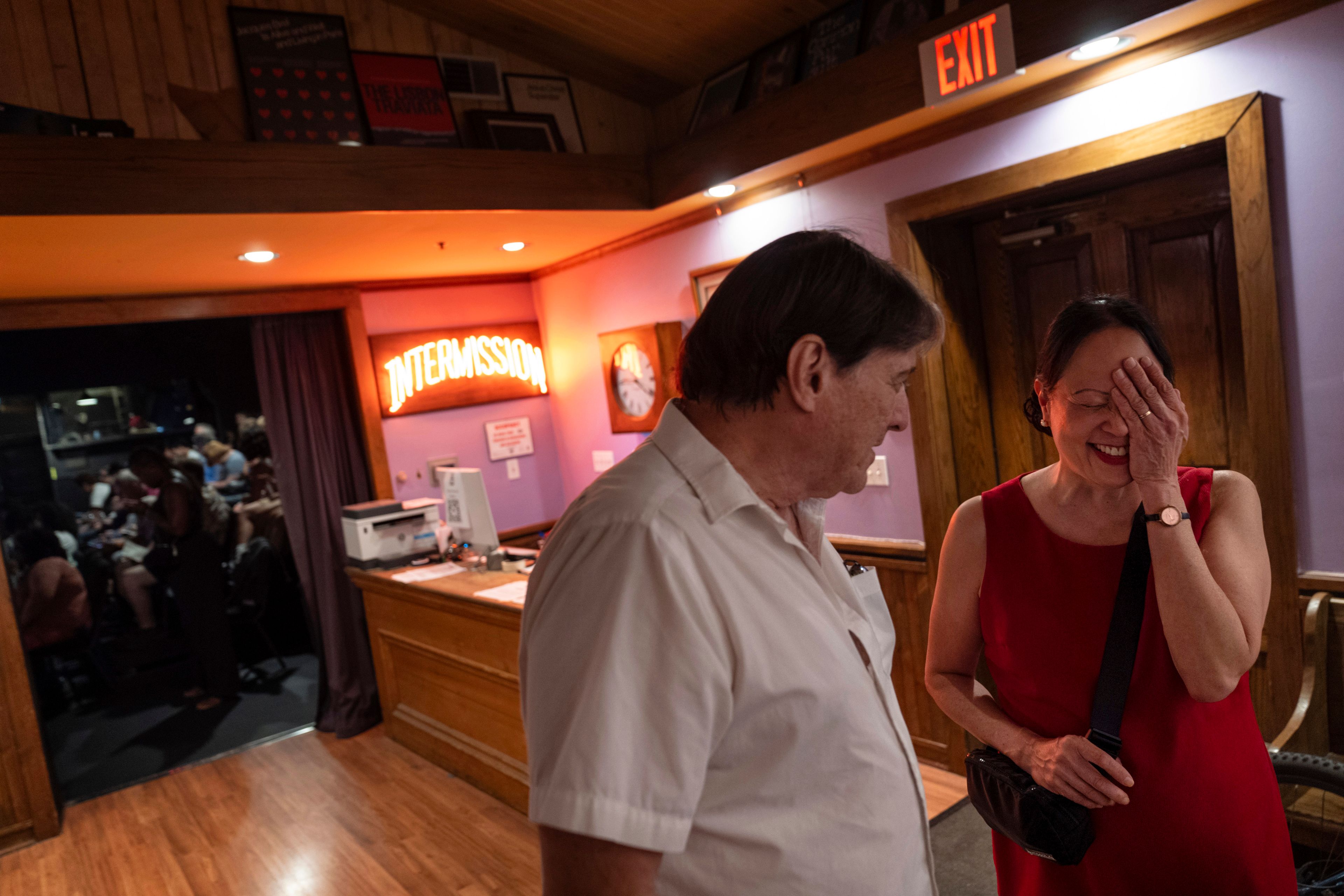 Matt, left, and Lesley Dzik, talk during intermission in the lobby of The Station Theatre while volunteering as ushers during a performance of "POTUS: Or, Behind Every Great Dumbass Are Seven Women Trying to Keep Him Alive," in Urbana, Ill., Saturday, Sept. 21, 2024. (AP Photo/David Goldman)