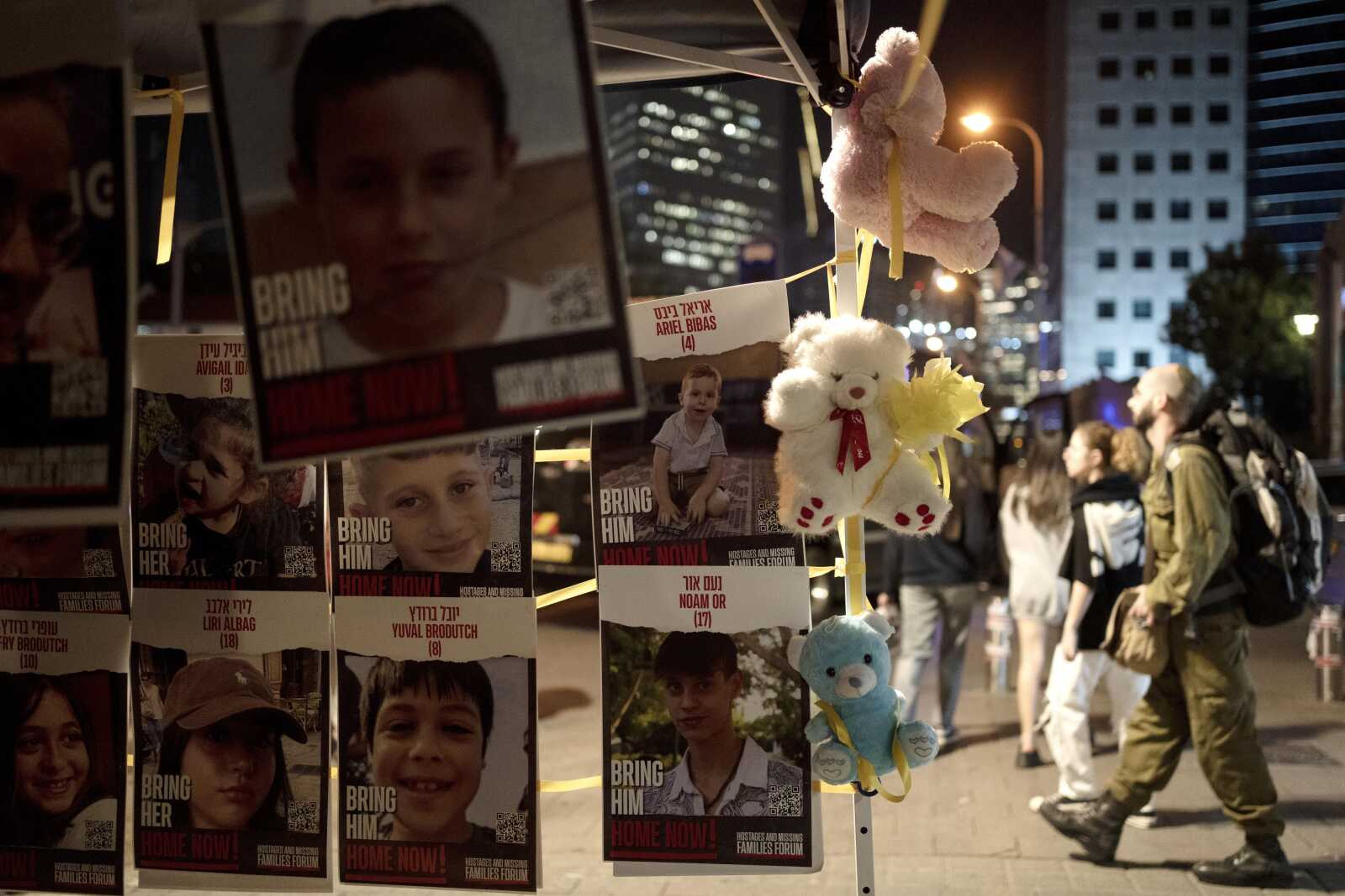 Posters of children held hostage by Hamas in the Gaza Strip are displayed with toys across from the Kirya, headquarters of Israel's Defense Forces ahead of an anticipated hostage release, in Tel Aviv, Israel, Thursday, Nov. 23, 2023. (AP Photo/Maya Alleruzzo)