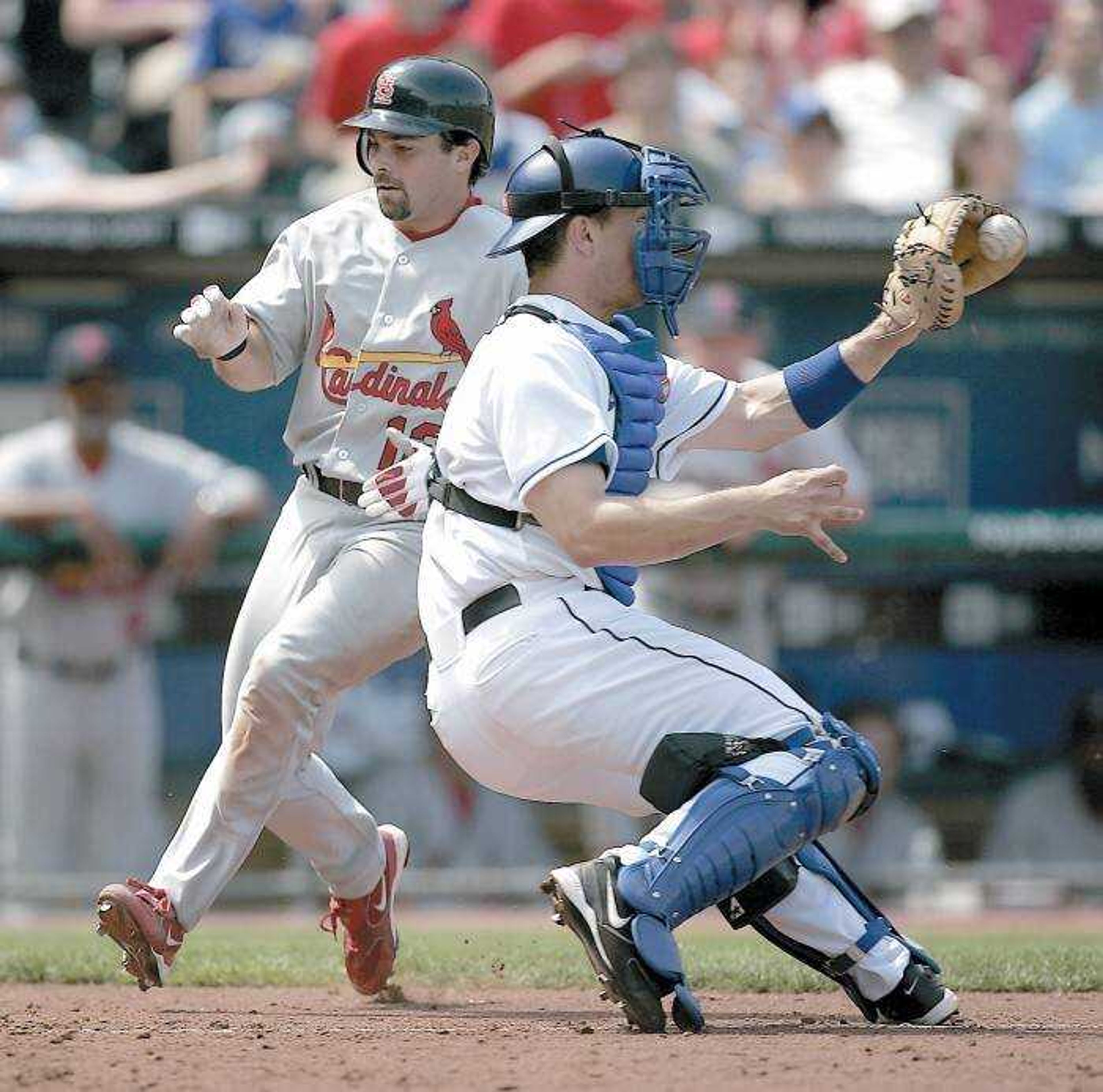 The Cardinals' Aaron Miles scored on a double by Jim Edmonds during the seventh inning as Royals catcher Paul Bako took the late throw Sunday in Kansas City, Mo. (Associated Press)