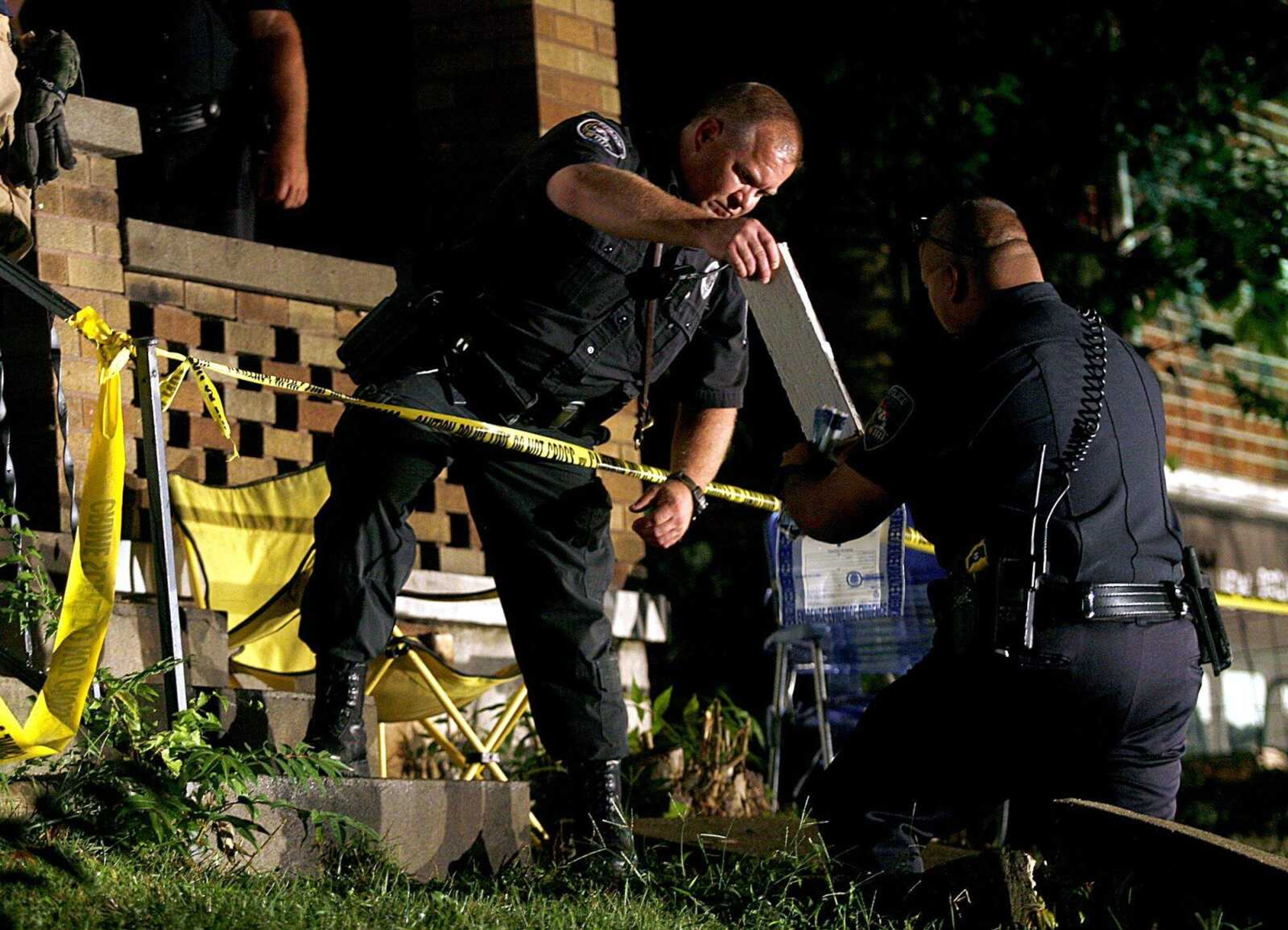 ELIZABETH DODD ~ edodd@semissourian.com
Patrolman Rahn, left, and Evidence Technician Cary Dunavan bagged evidence at the shooting crime scene on Hanover St. Wednesday night.