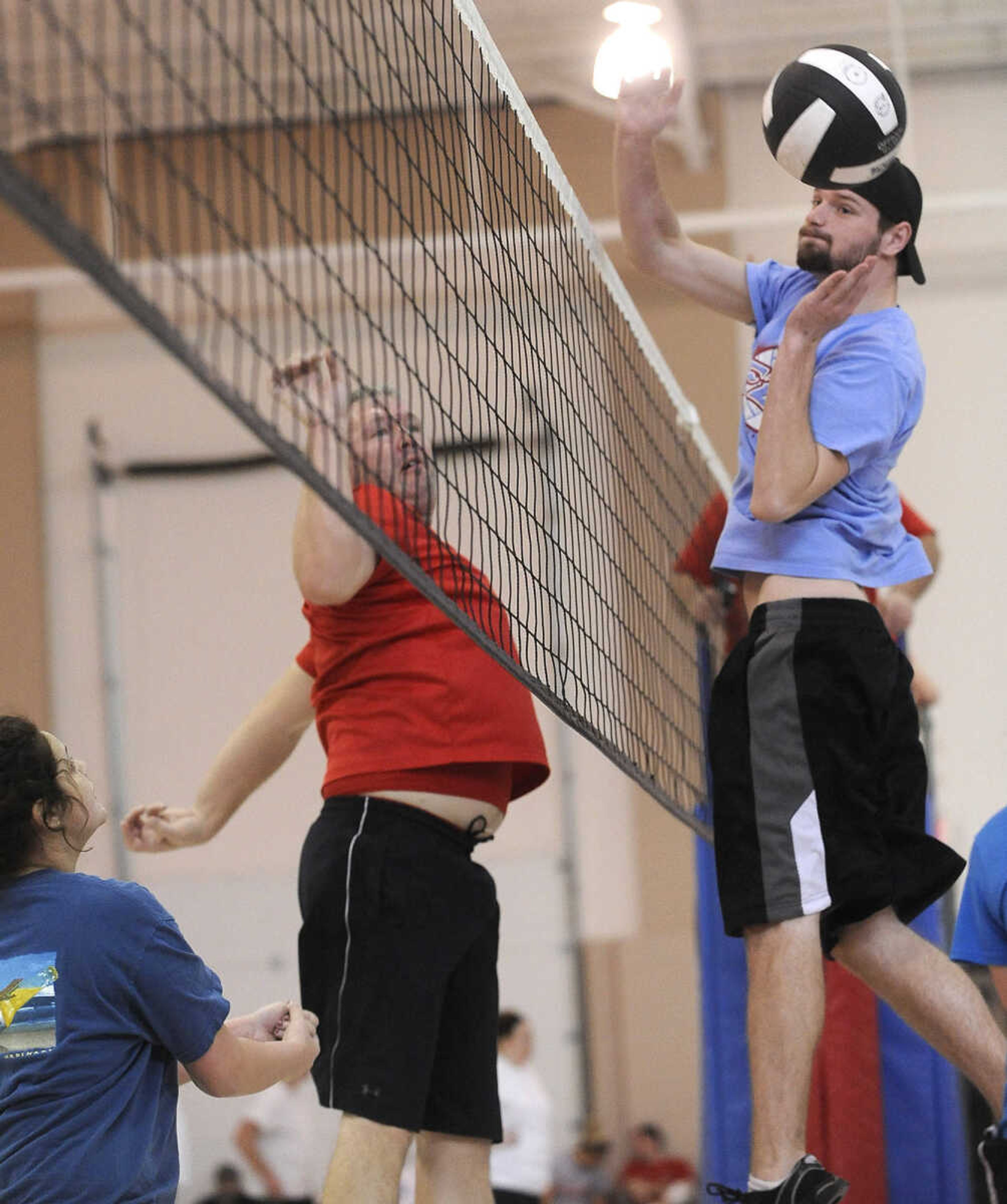 Matthew Whitmore of The Original Justice League team reacts to a spike by Chad Beck of the Unprotected Sets team in the Osage Invitational Co-ed Volleyball Tournament Sunday, March 1, 2015 at the Osage Centre.