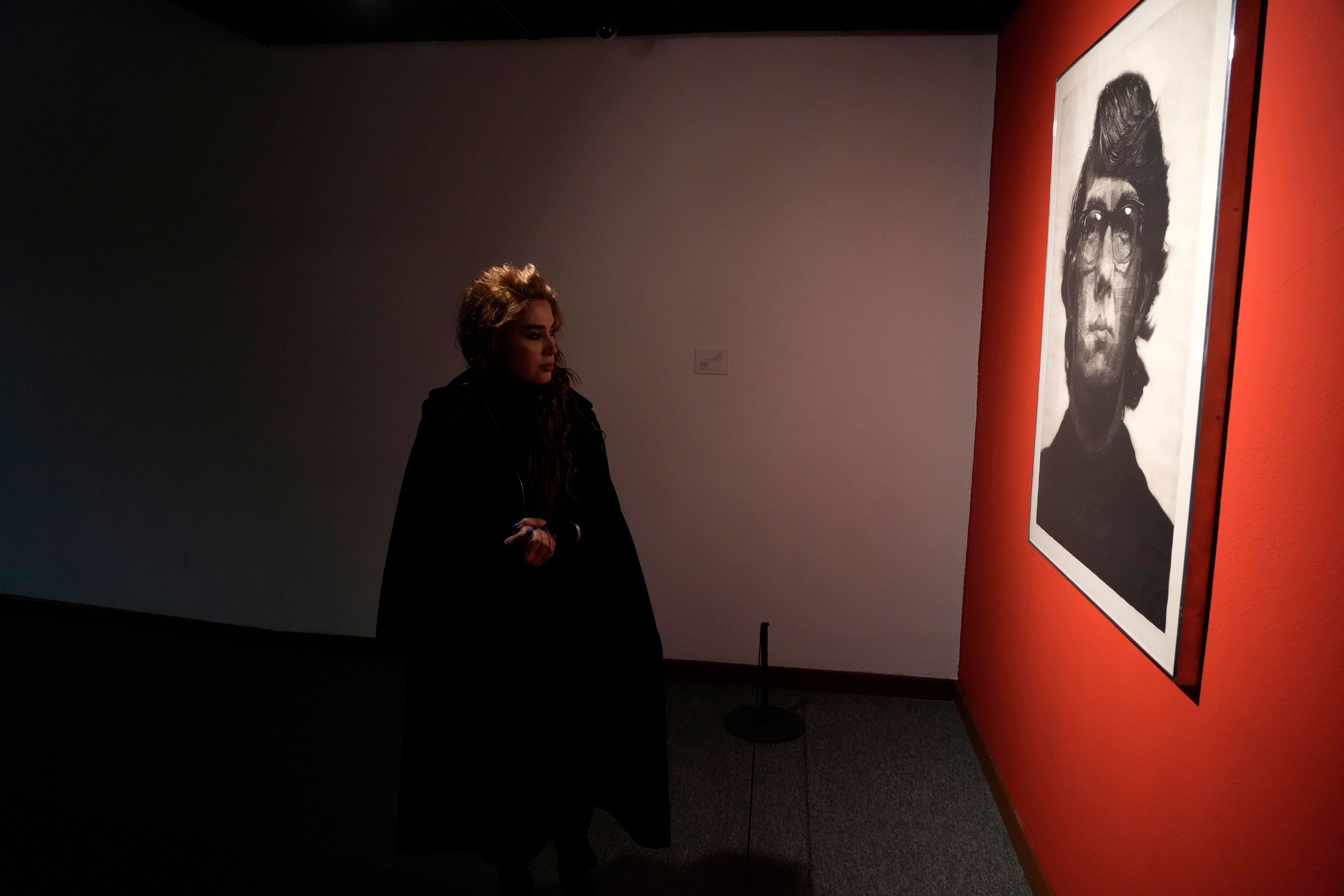 A visitor looks at an artwork by American artist Chuck Close as she visits an exhibition titled Eye to Eye which showcases over 120 works by modern world artists as well as Iranian painters at Tehran Museum of Contemporary Art, in Tehran, Thursday, Nov. 21, 2024. (AP Photo/Vahid Salemi)