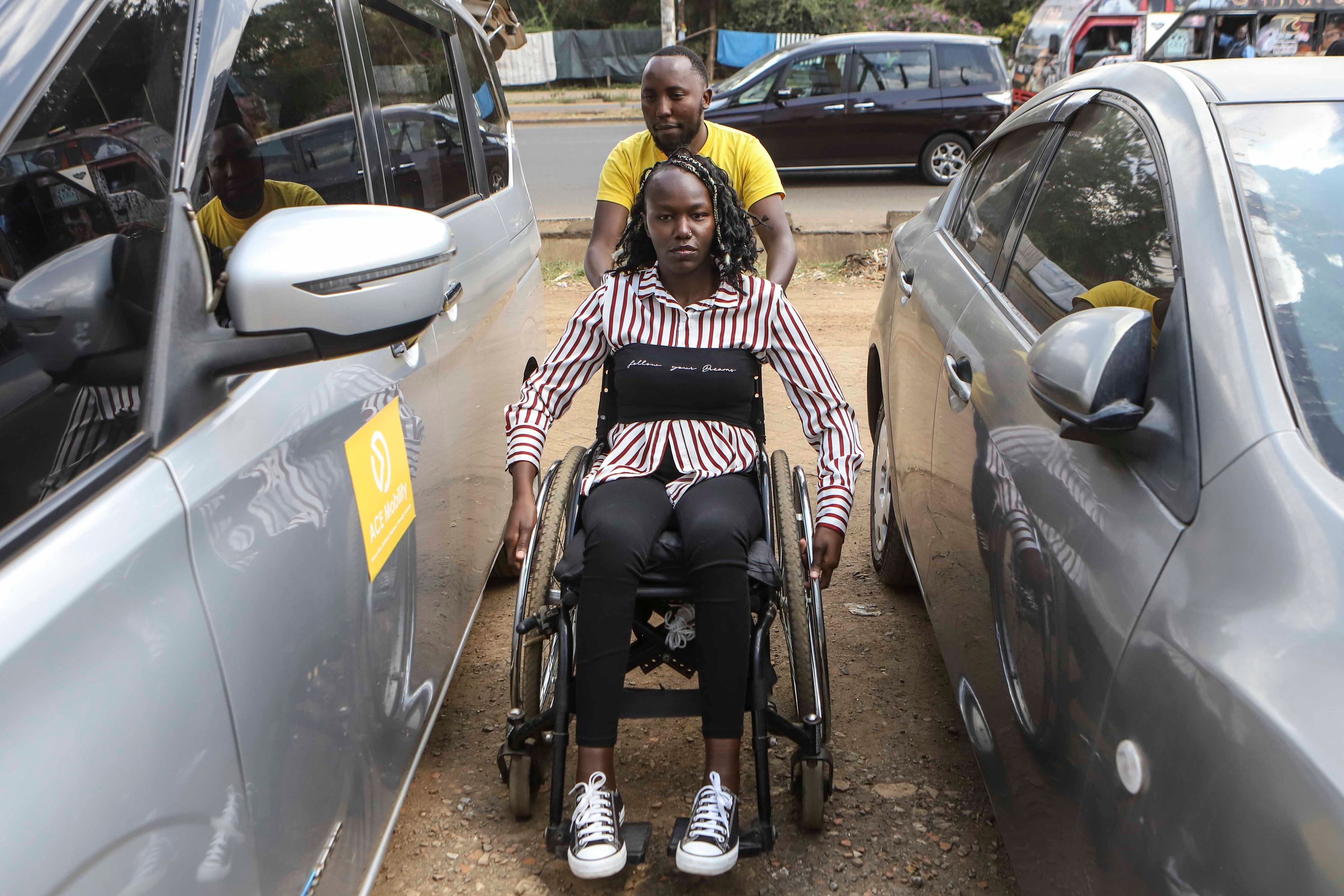 Daniel Gatura, Co-founder of Ace Mobility company, helps Carol Mwikali to get inside Ace Mobility vehicle in Nairobi, Kenya Wednesday, Oct. 9, 2024. (AP Photo/Andrew Kasuku)