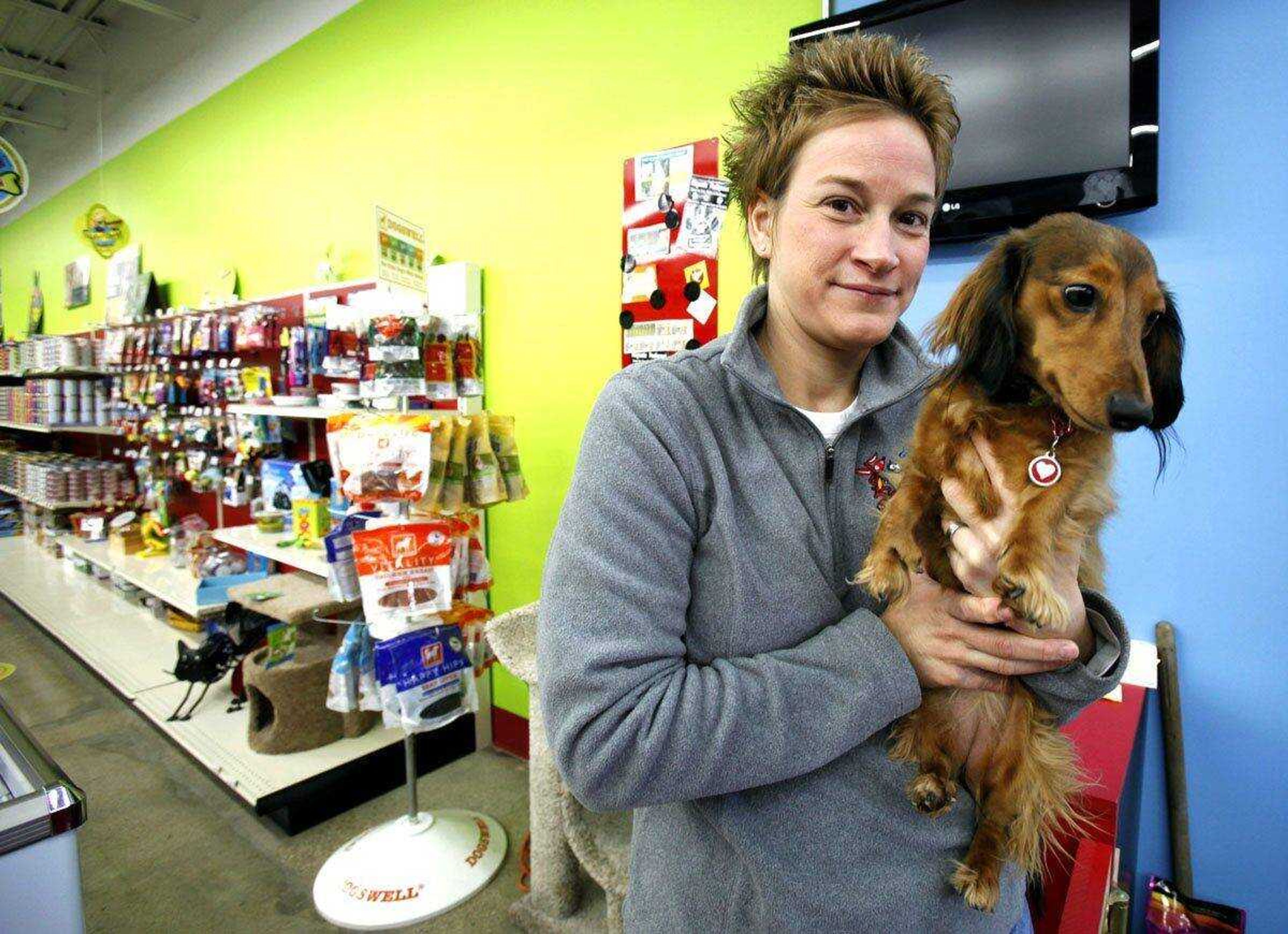 April Lawrence, owner of Bone-a-patreat, holds her dog Roma in her Des Moines, Iowa, store Jan. 30. (Charlie Neibergall ~ Associated Press)