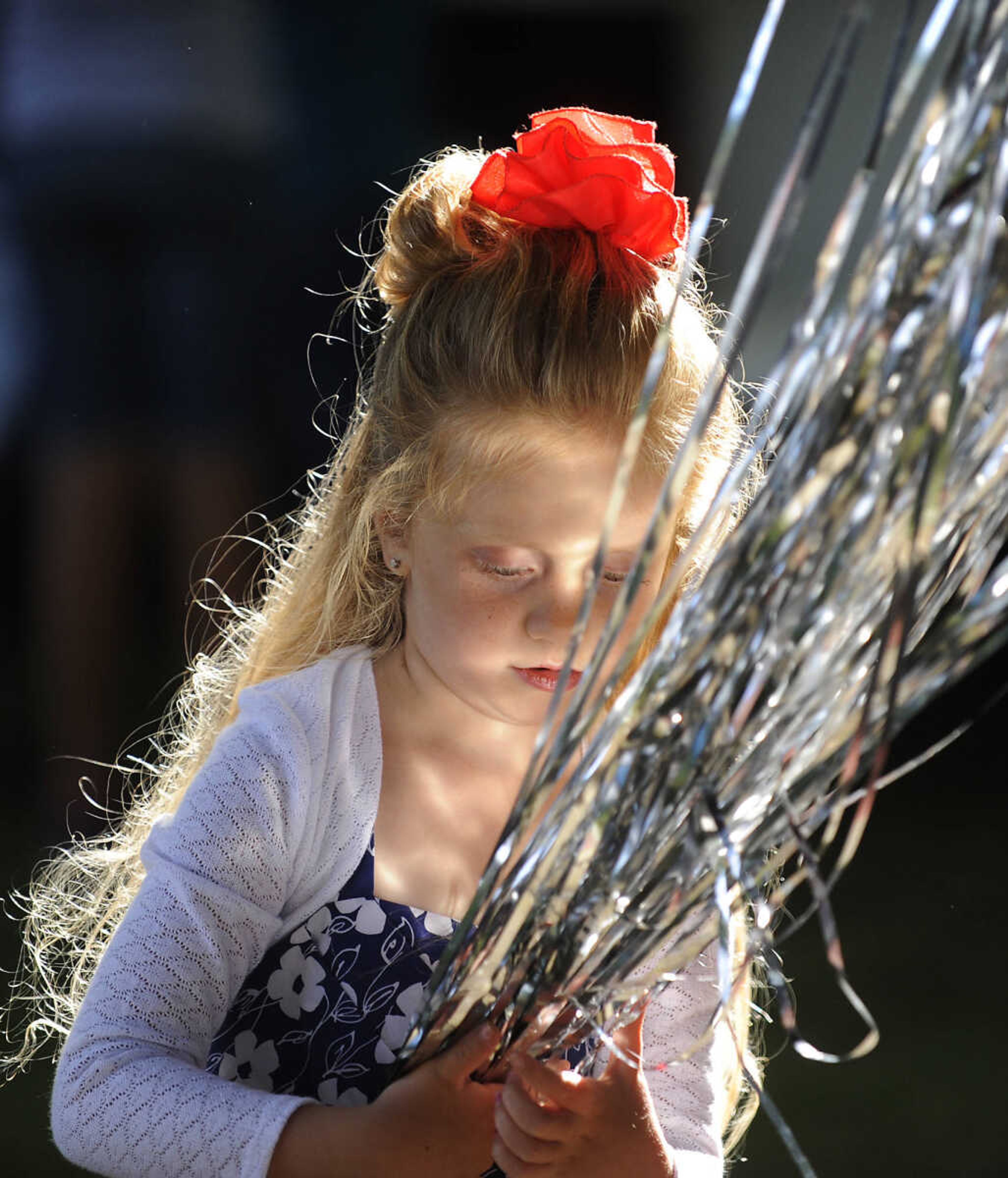 Ramsey Spinks, 5, plays with some of the decorations before the Summerfest Pageant Show at the 36th annual Scott City Summerfest Friday, June 1, at Scott City Park.