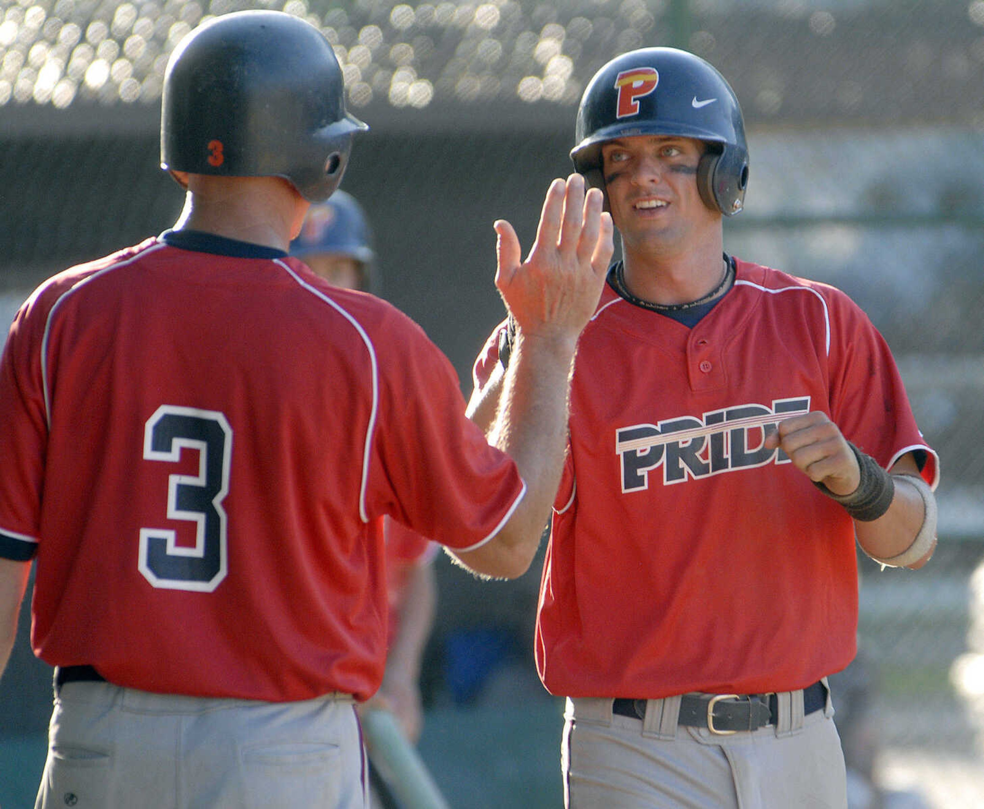 Decatur Pride's Cole Koester is congratulated by teammate Rick Minton after hitting an inside-the-park home run against Nokomis during the fourth inning of the championship game Sunday at the Kelso Klassic.