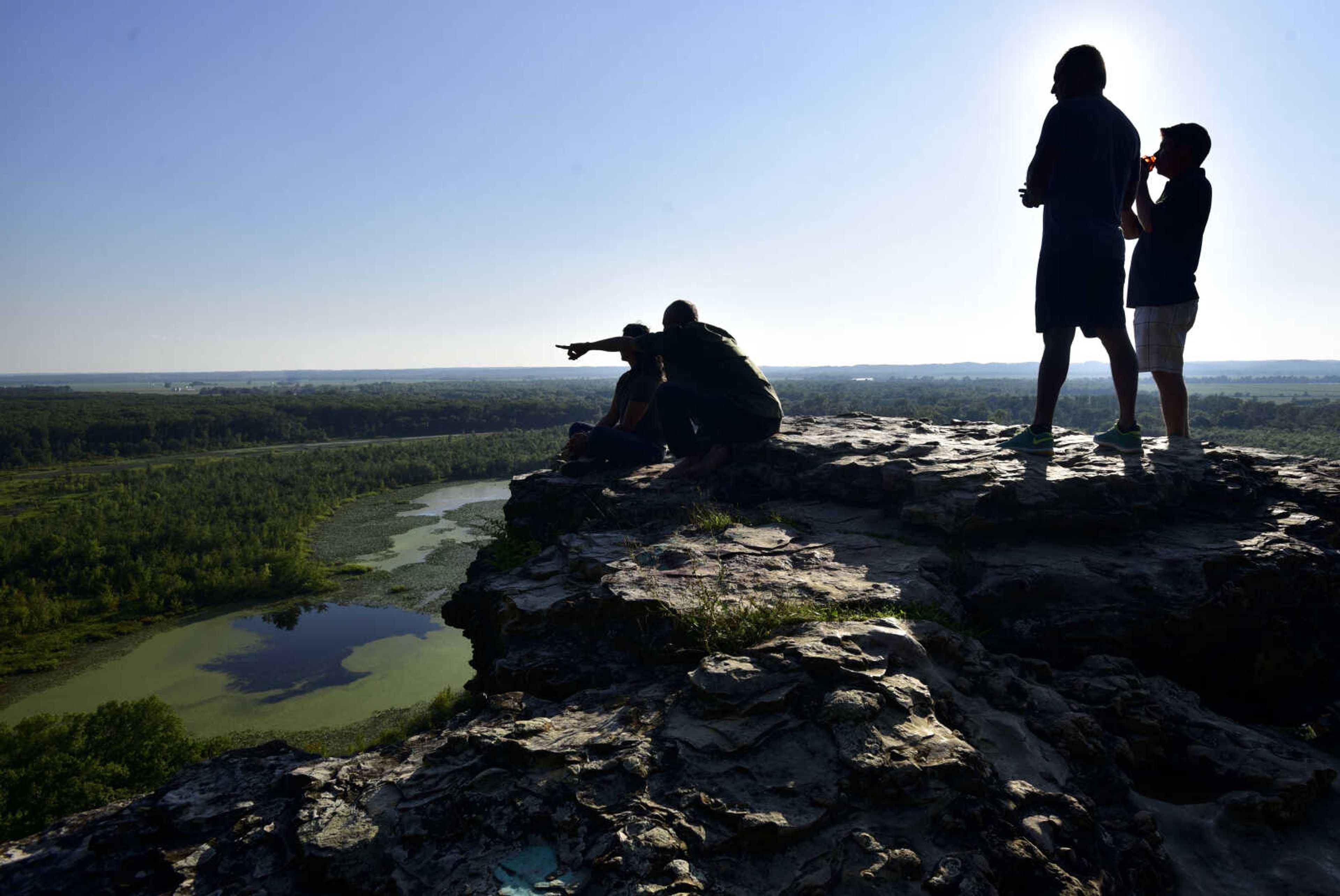 Visitors point out features in the landscape while taking in the view at Inspiration Point overlook Wednesday, Aug. 1, 2018, near Wolf Lake, Illinois.