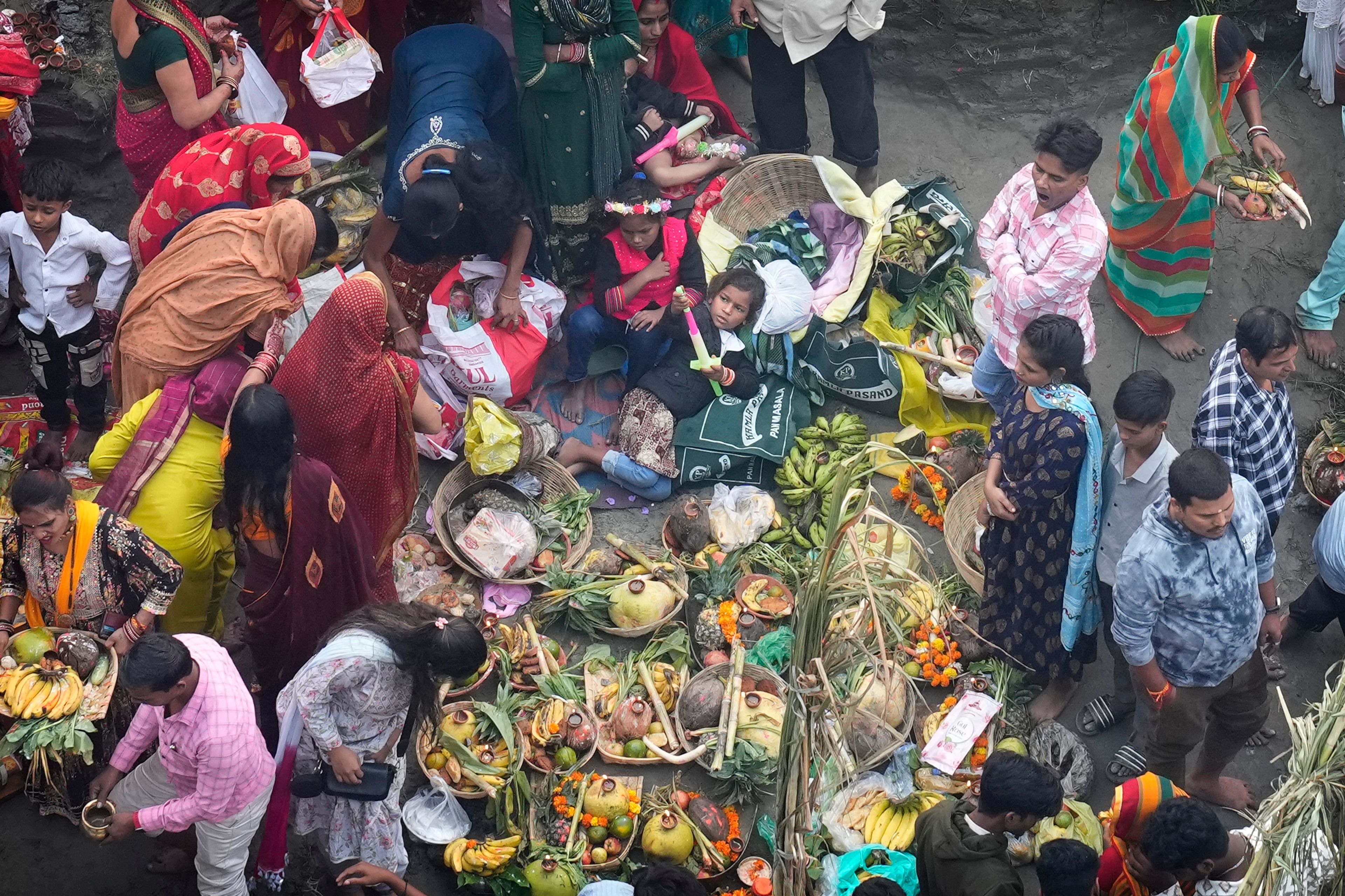 A child lies next to offerings brought by devotees on the banks of the river Yamuna during Chhath festival in Noida, near New Delhi, India, India, Friday, Nov. 8, 2024. (AP Photo/Manish Swarup)