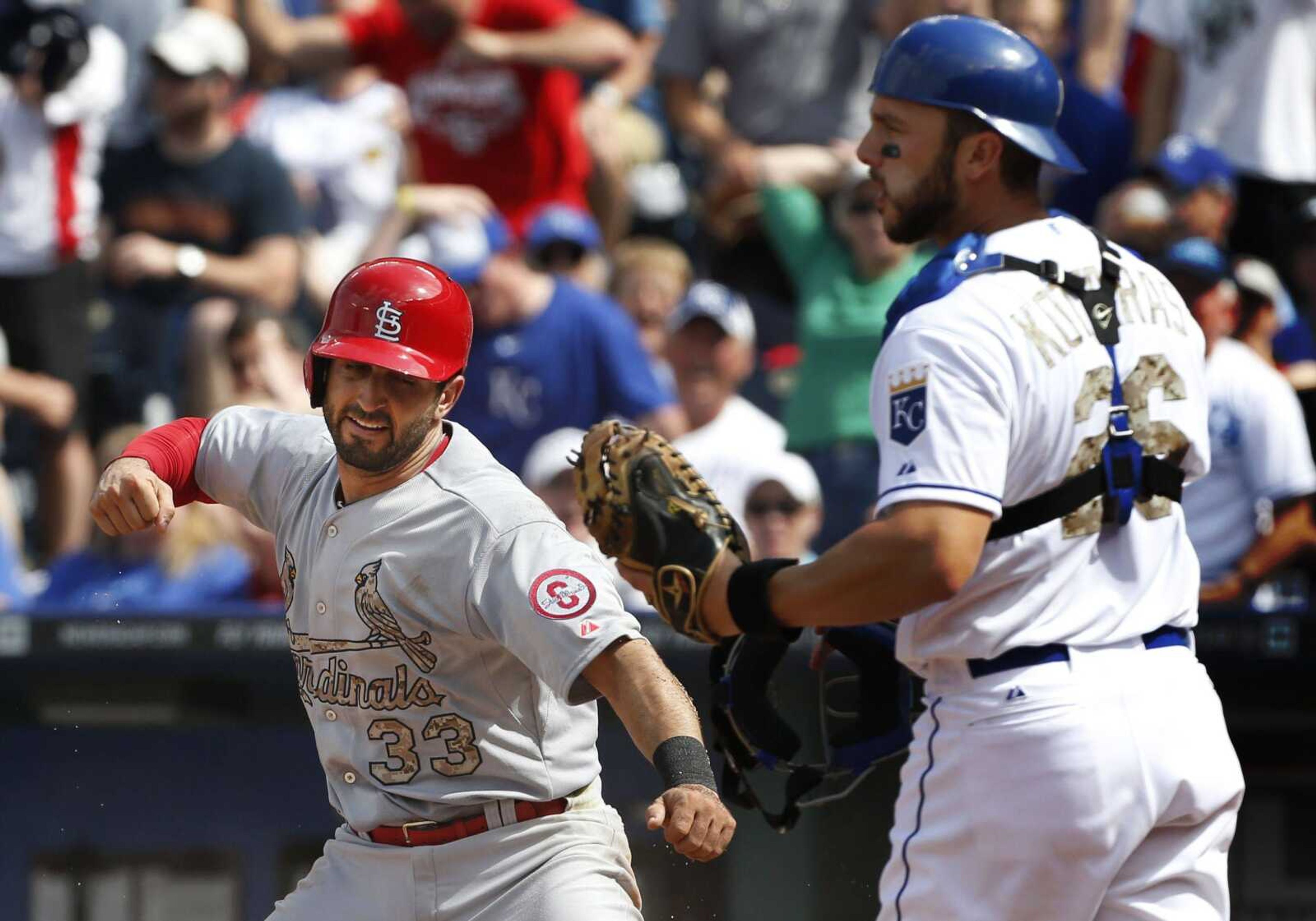 ABOVE: Cardinals second baseman Daniel Descalso celebrates in front of Royals catcher George Kottaras after scoring from first on a two-out double by Matt Carpenter during the sixth inning Monday in Kansas City, Mo. TOP: Descalso avoids the tag attempt by Kottaras. (Orlin Wagner ~ Associated Press)