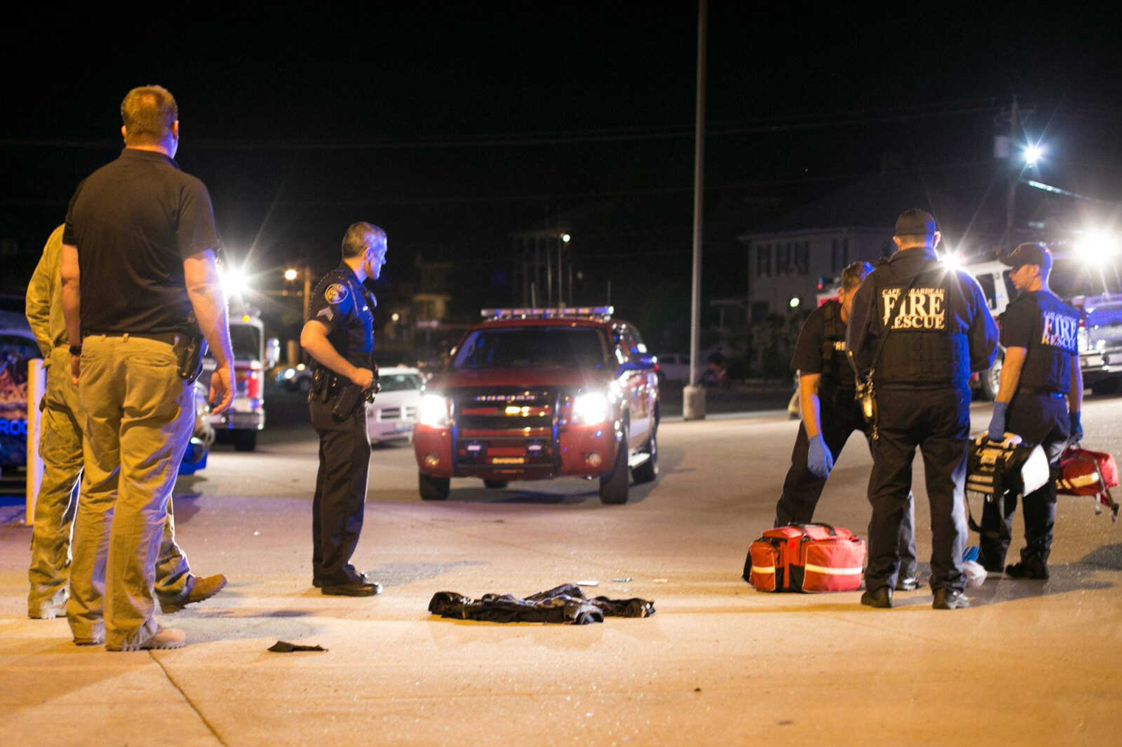 Police officers watch over the victim’s clothes after a shooting Thursday in the KFVS12 parking lot in downtown Cape Girardeau.