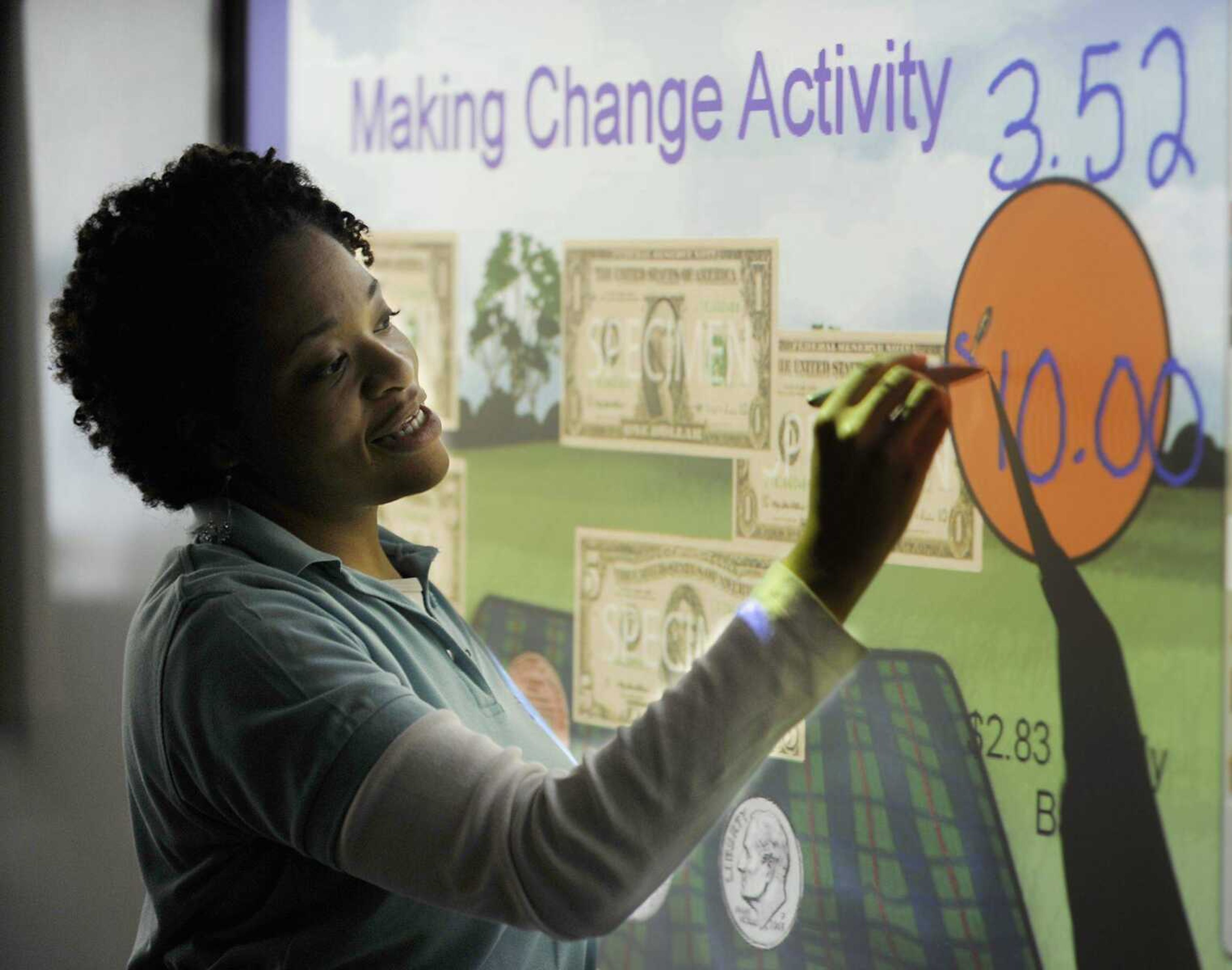 Malissa Beecham uses a Promethean board during a lesson on making change in her fourth grade class Friday, October 19, at Franklin Elementary School. The new school is the only one in the district to have the interactive display boards. (ADAM VOGLER)