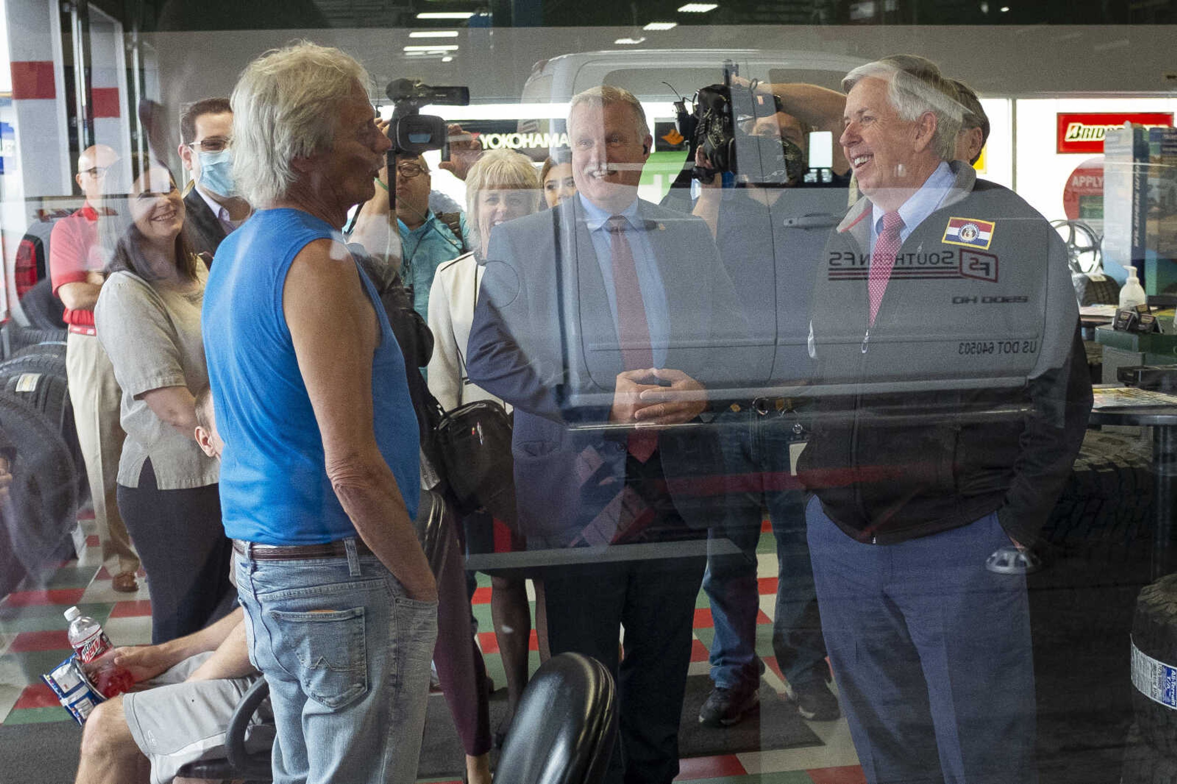 Missouri Gov. Mike Parson, right, speaks with Terry Boese of Cape Girardeau, left in blue, while making a visit Thursday, May 14, 2020, at Plaza Tire Service at 170 S. Kingshighway in Cape Girardeau.