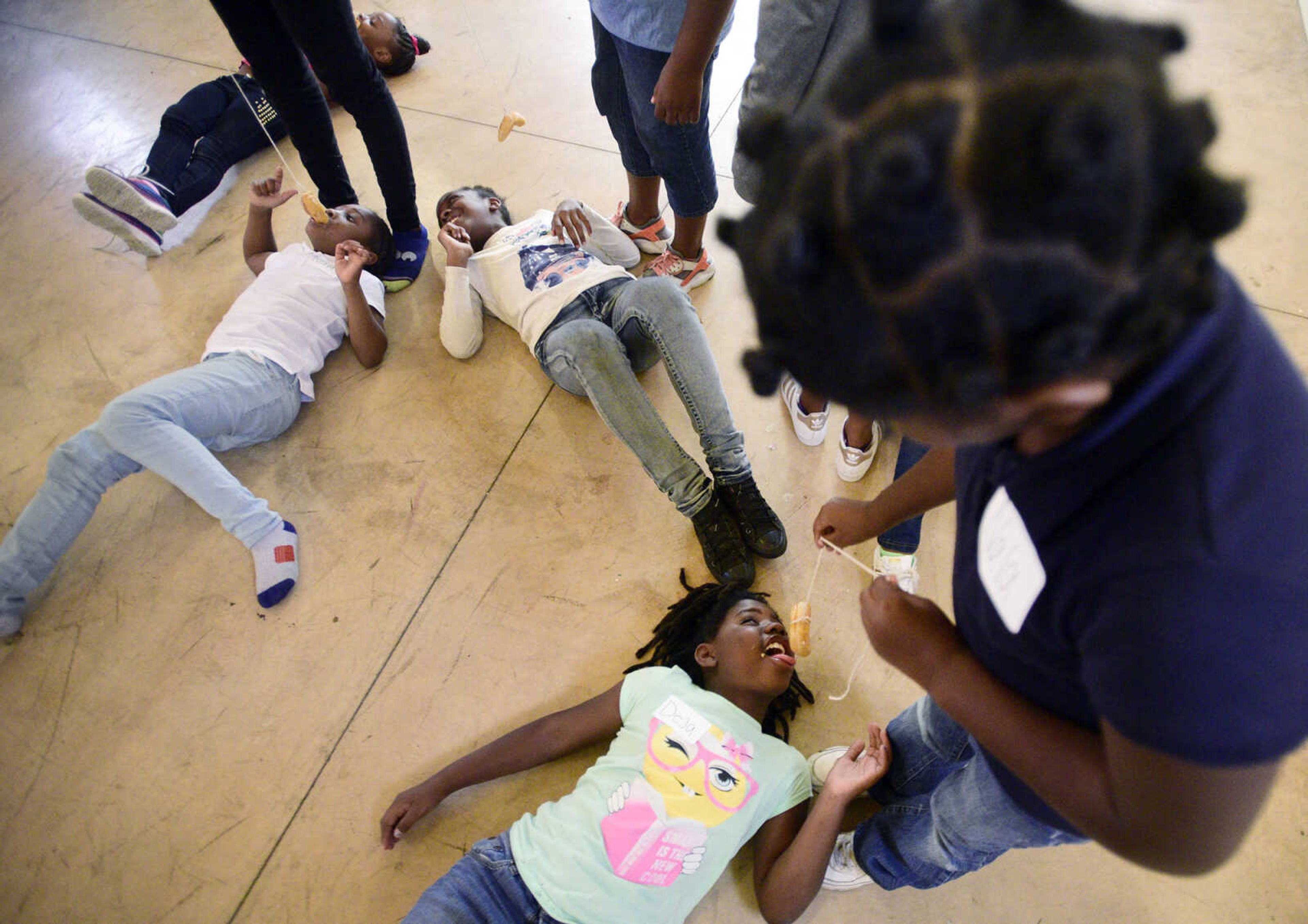 Nala Maney dangles a donut above her sister Deja on Monday, Aug. 14, 2017, during the Salvation Army's after school program at The Bridge Outreach Center in Cape Girardeau.