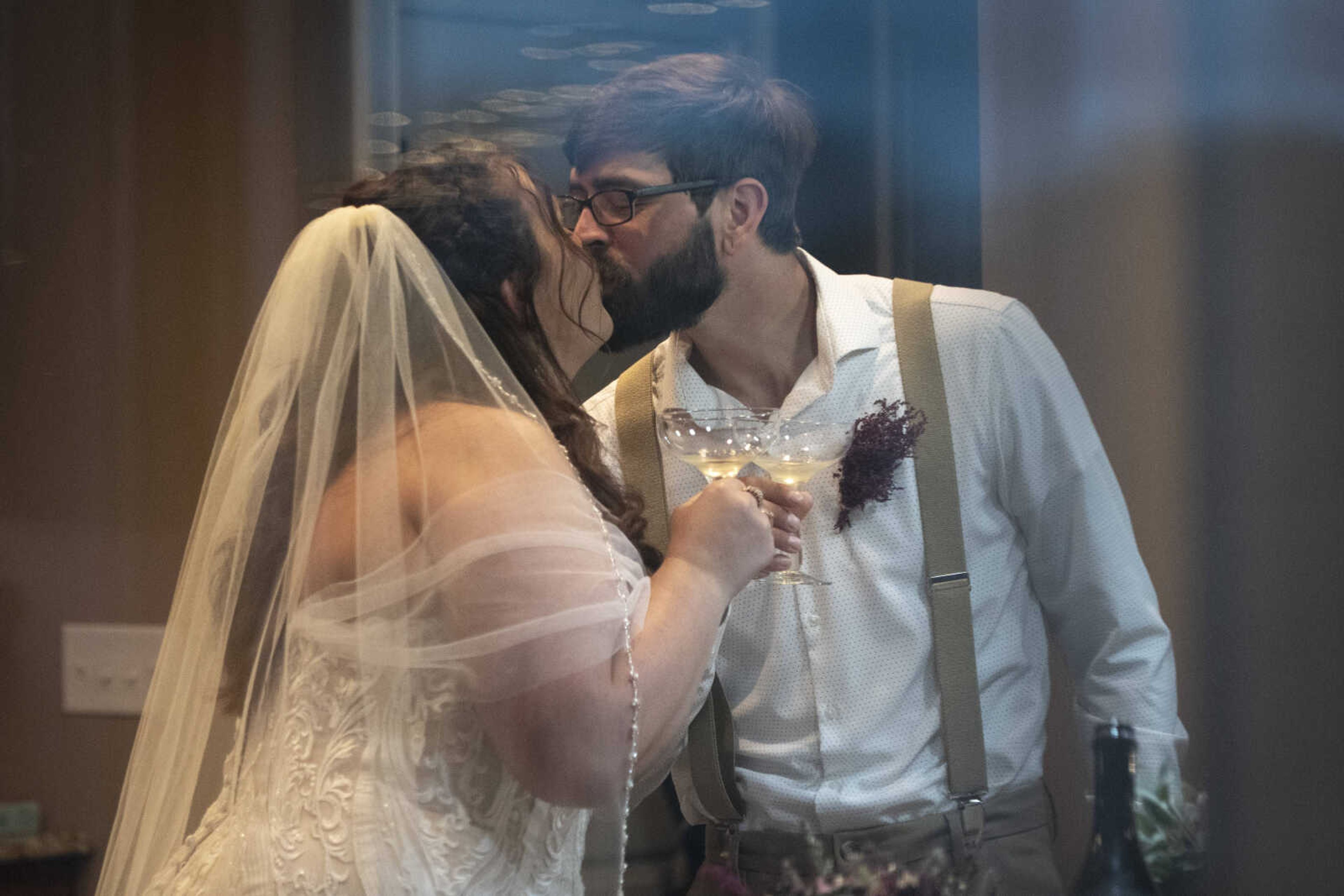 Trevor Kroenung and Jenni (Heisserer) Kroenung share a kiss while celebrating indoors shortly after being married Saturday, April 25, 2020, in Scott County, Missouri.