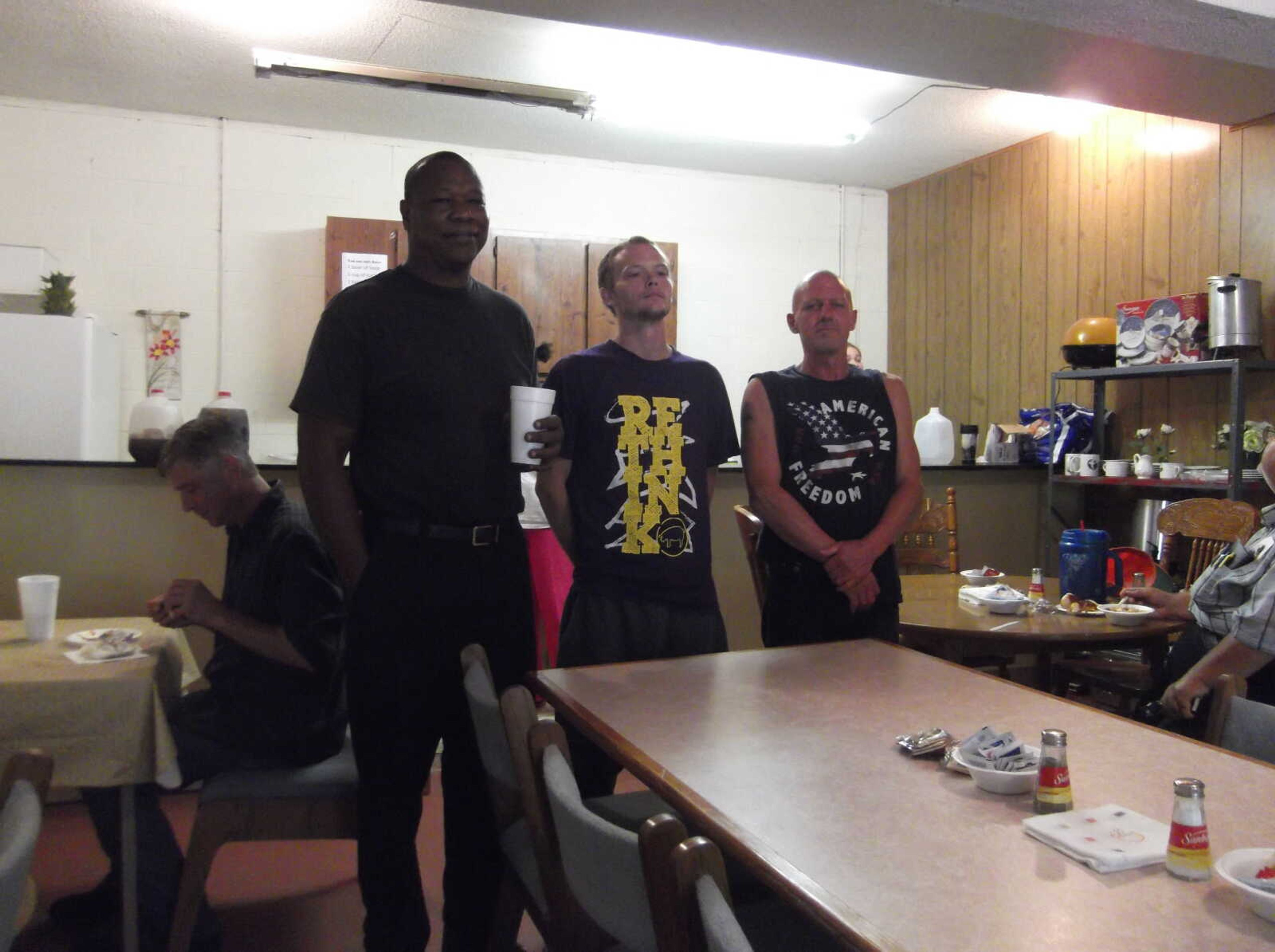 Pastor Aaron Robinson, Andy Lee and Lance Farrow enjoy some chilli, and juice at The New Beginnings Soup Kitchen.