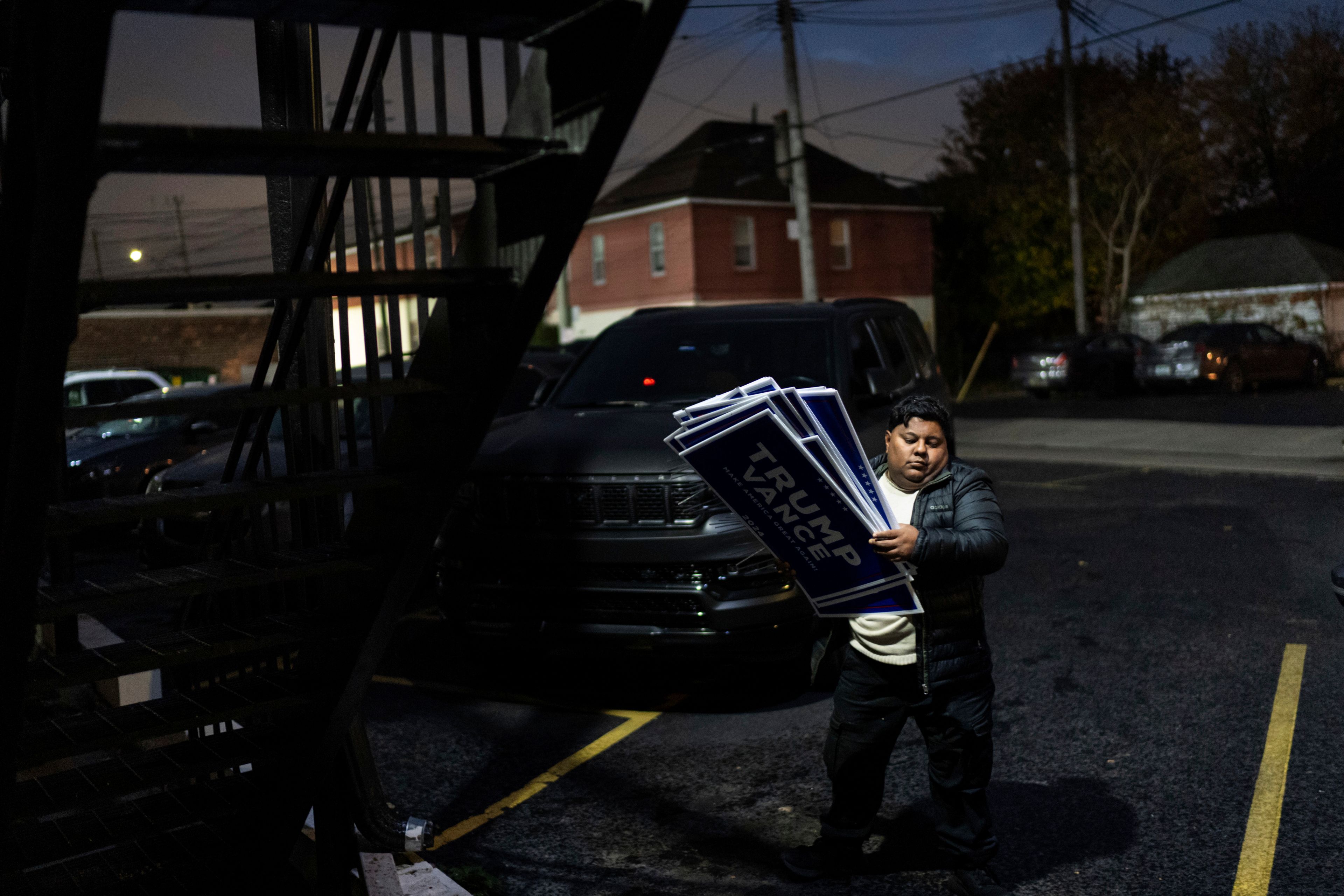 Arif Armanjisan helps carry yard signs into a campaign office for Republican presidential nominee former President Donald Trump the night before the general election Monday, Nov. 4, 2024, in Hamtramck, Mich. (AP Photo/David Goldman)