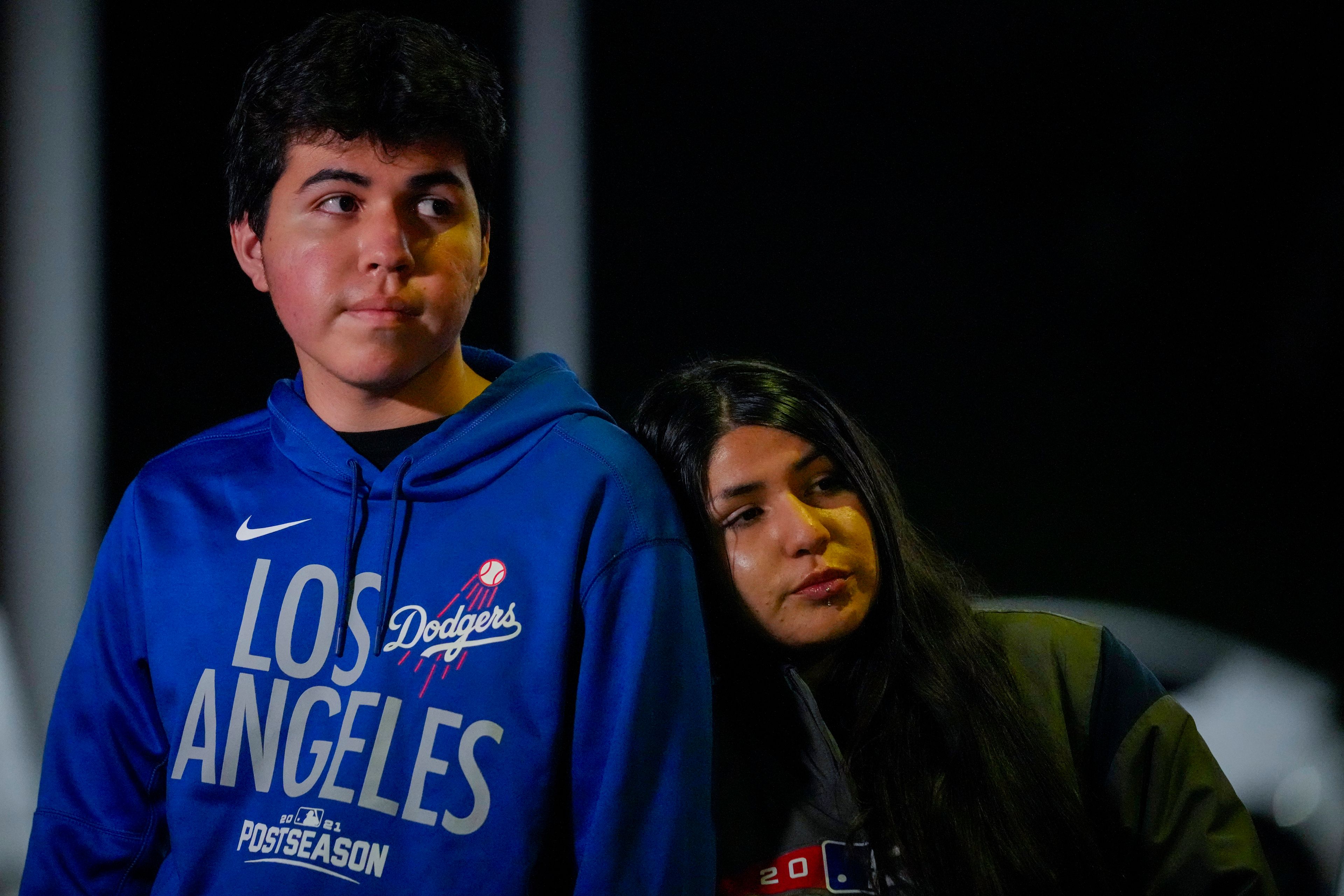 Sergio Juarez, 16, left, and his sister Bianca Juarez, 23, stand near the entrance to Dodger Stadium to pay respects to former Los Angeles Dodgers pitcher Fernando Valenzuela, Tuesday, Oct. 22, 2024 in Los Angeles. Valenzuela, the Mexican-born phenom for the Los Angeles Dodgers who inspired "Fernandomania" while winning the NL Cy Young Award and Rookie of the Year in 1981, has died Tuesday, Oct. 22, 2024. (AP Photo/Julio Cortez)