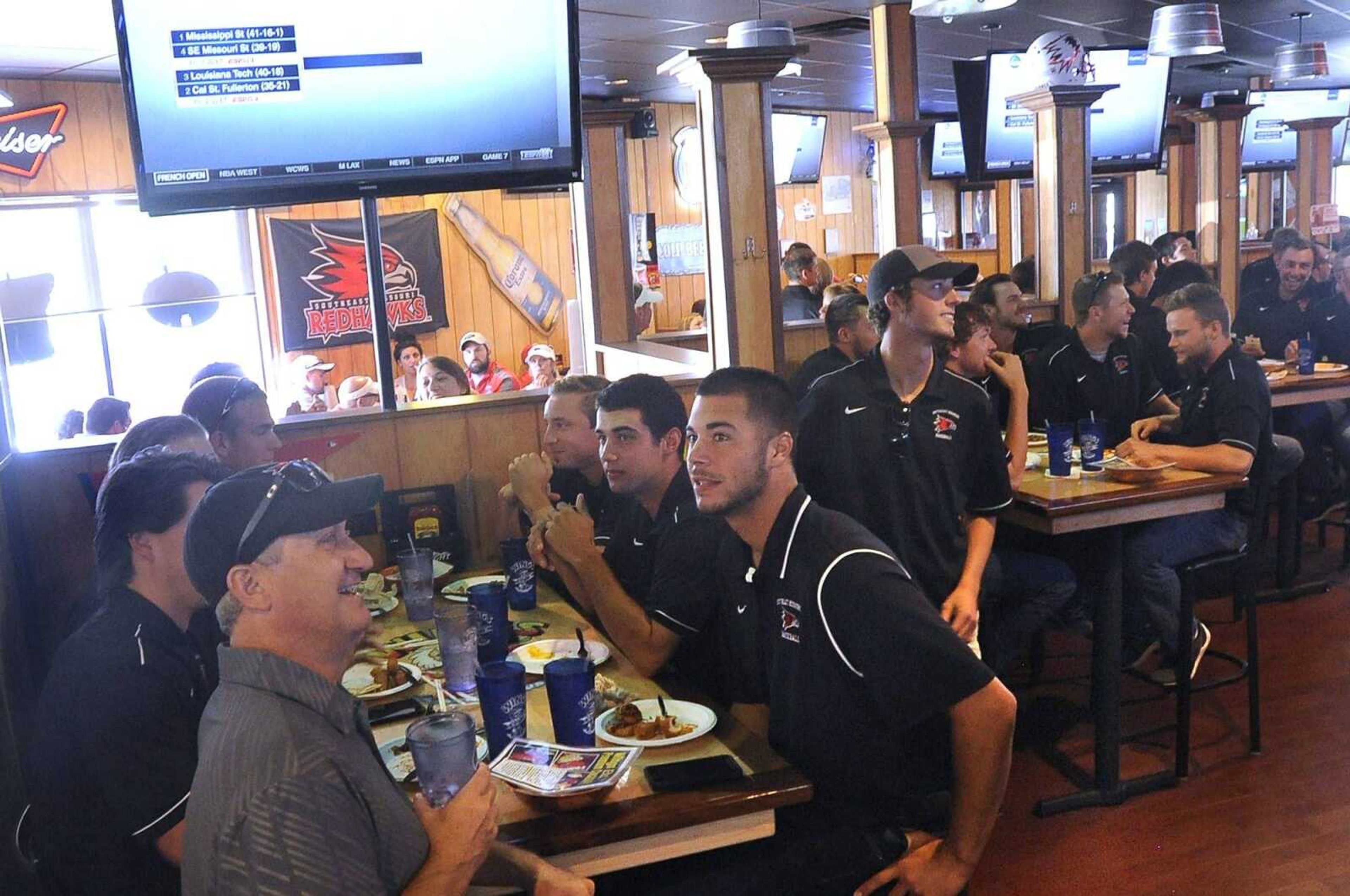 The Southeast Missouri State baseball team looks on as it learns its NCAA Regional fate during a watch party at Wings, Etc. in Cape Girardeau on Monday. The Redhawks will be traveling to Starkville, Mississippi, to take on Mississippi State.