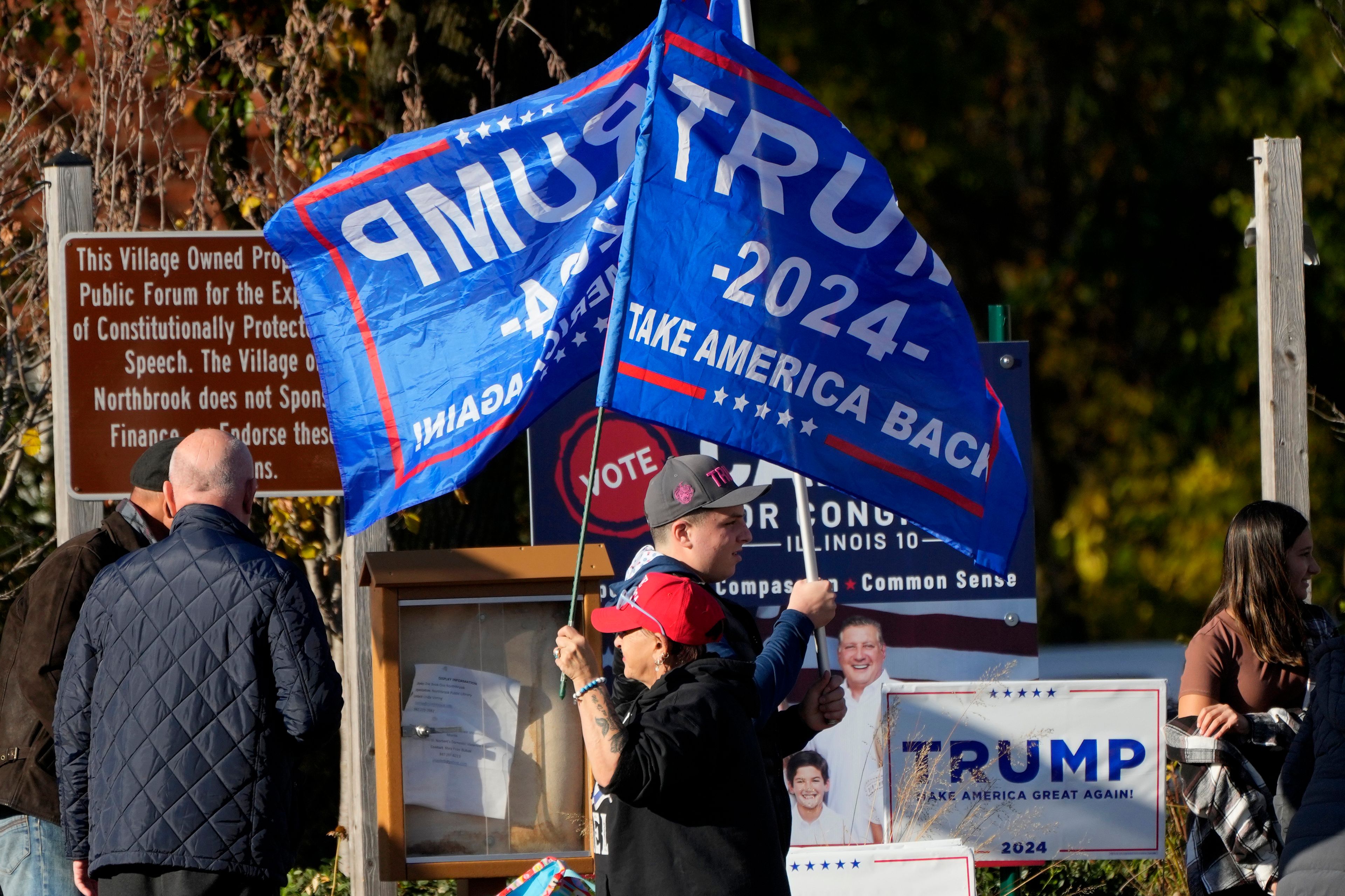 Supporters of Republican presidential nominee former President Donald Trump hold up flags during a Trump rally in Northbrook, Ill., Sunday, Oct. 27, 2024. (AP Photo/Nam Y. Huh)